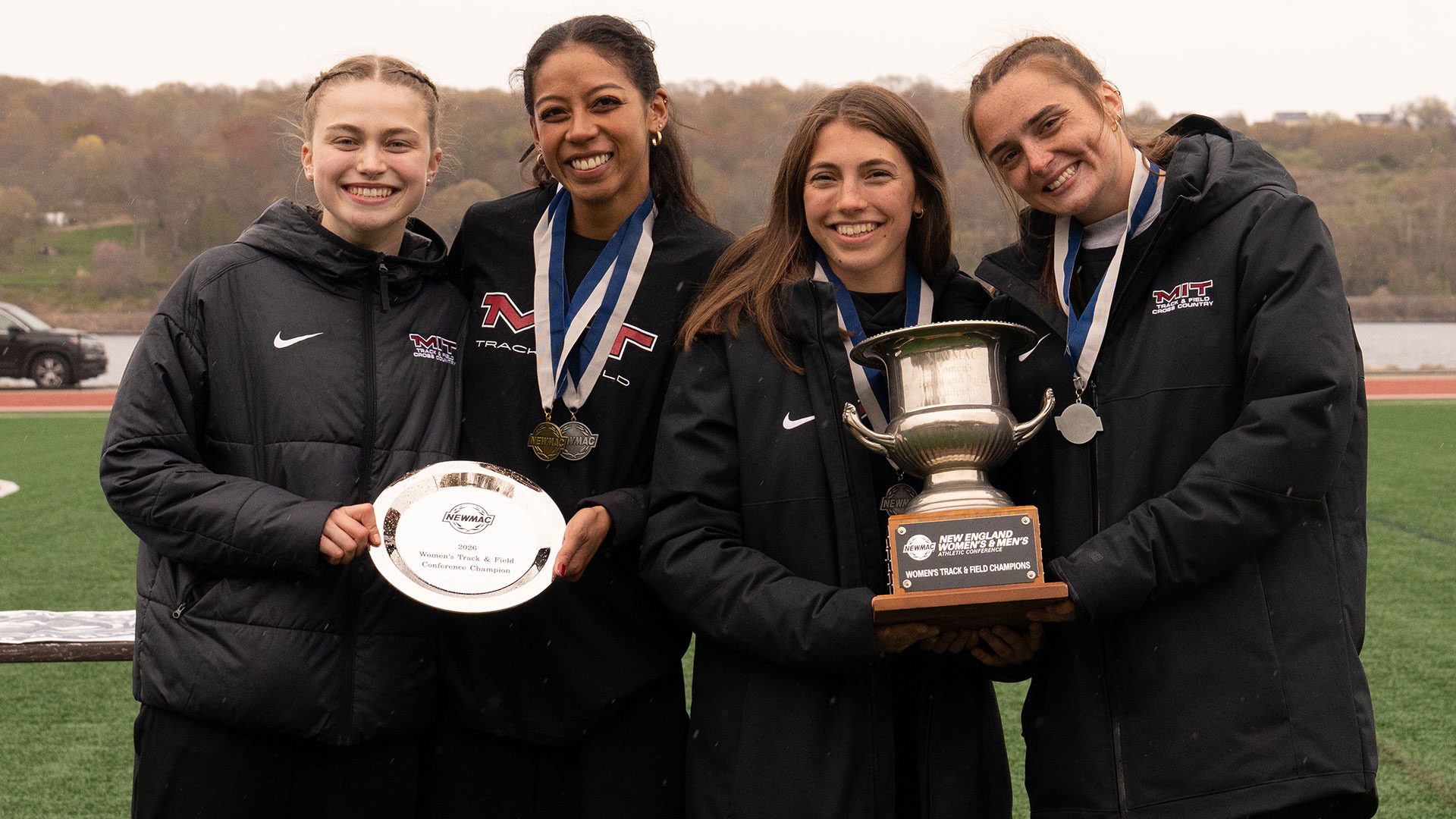 KAte Sanderson, Krystal Montgeomery, Hailey Surace and Katie Kempff with the NEWMAC Championship trophy