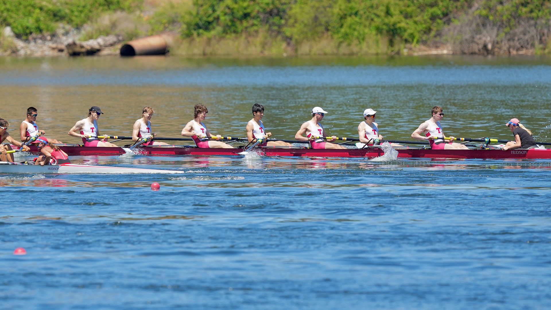 men's lightweight varsity eight rowing on a lake