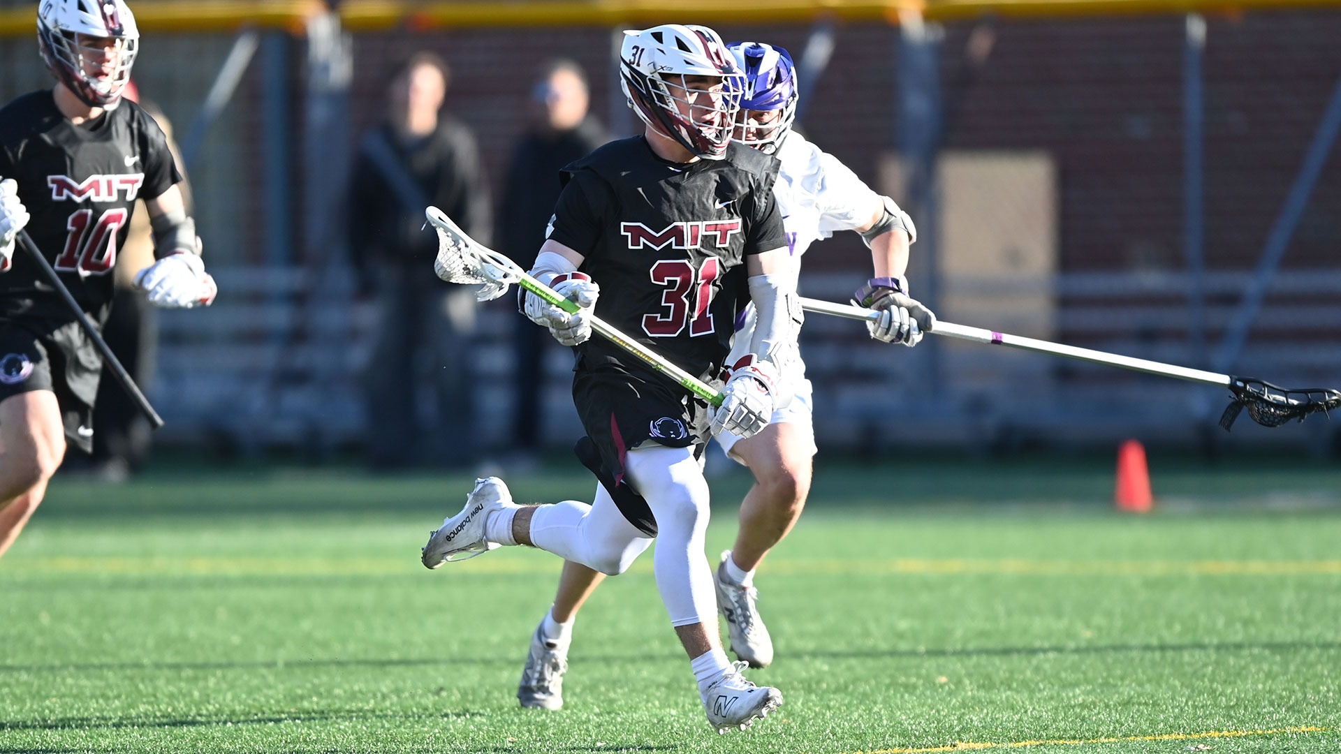 Kaden Fenno running down the field with the ball in his lacrosse stick