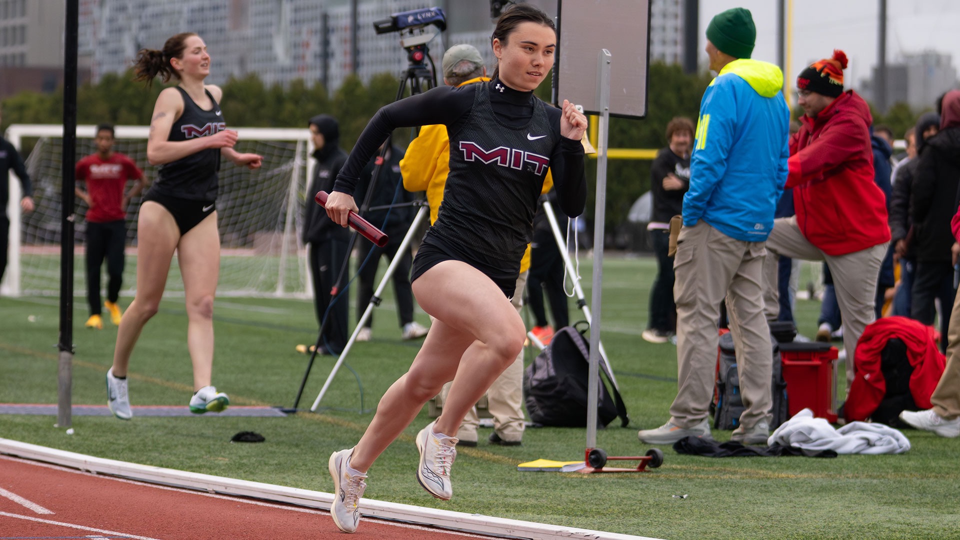 Madeline Hon running a relay race on a track