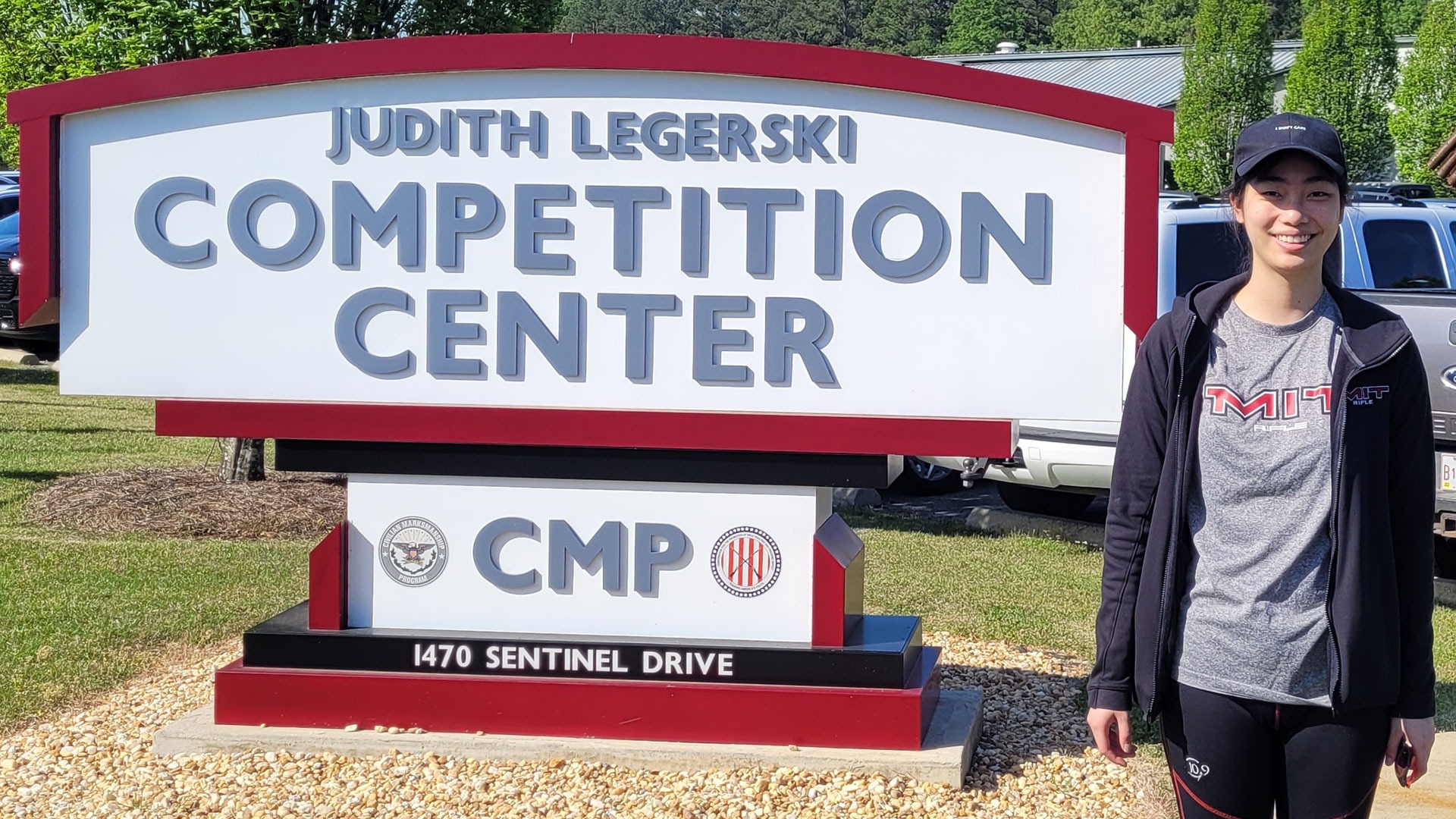 Eleanor Yang standing in front of a sign for the Judith Legerski CMP Competition Center
