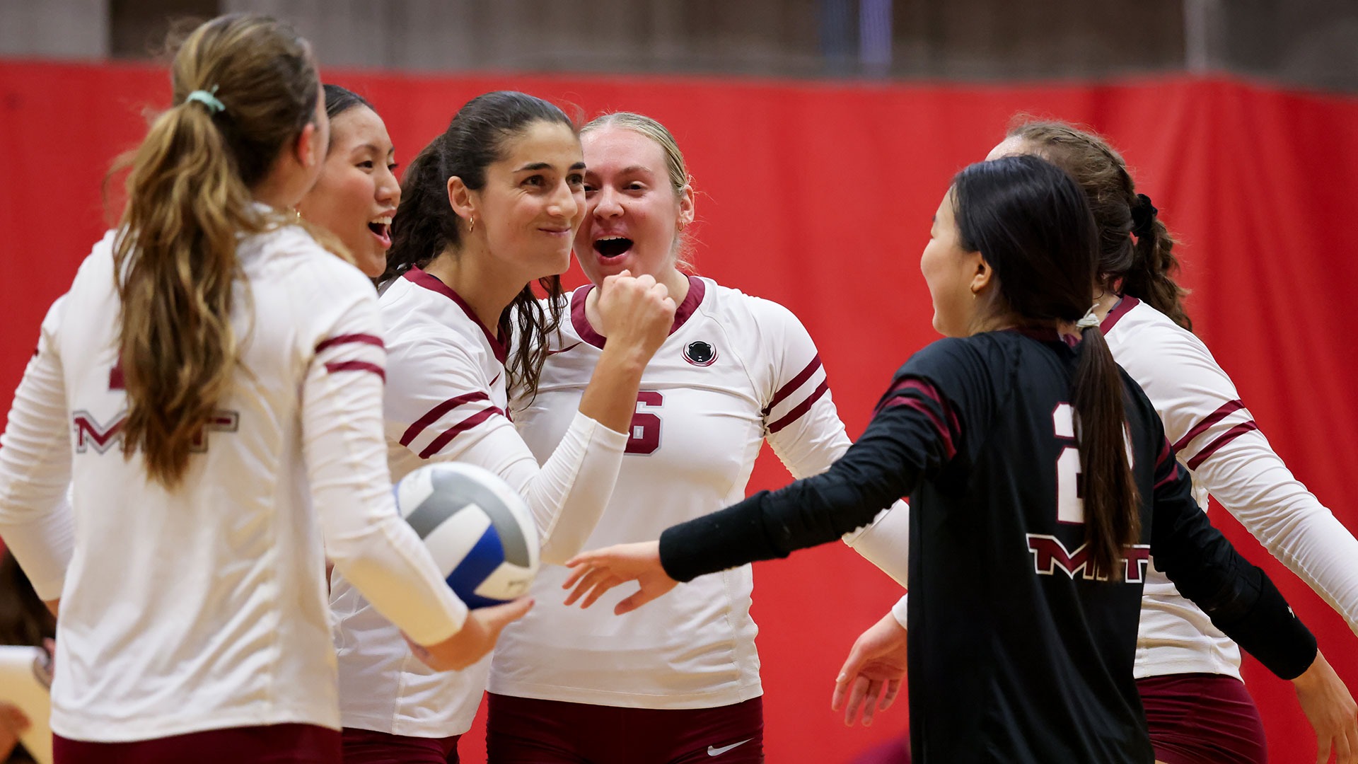 Members of the women's volleyball team celebrating