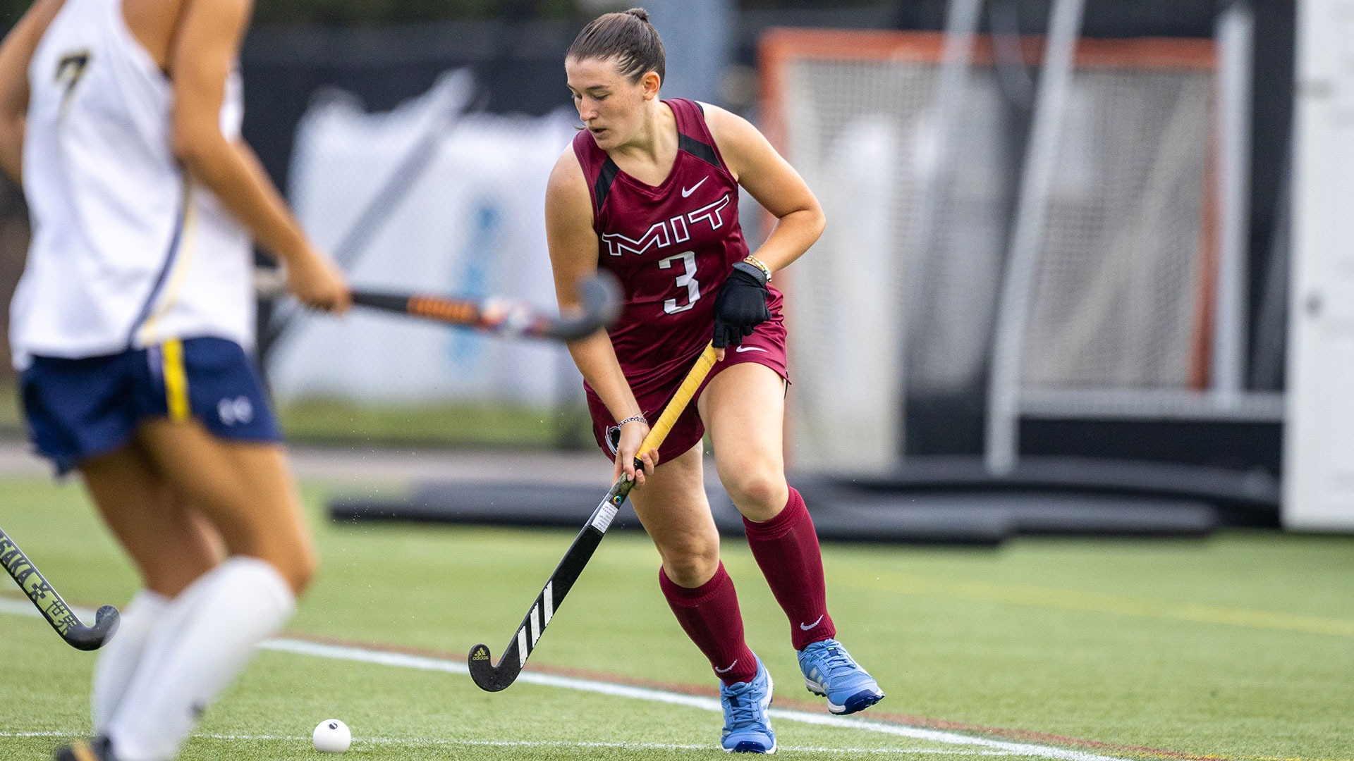 Drew Hussar running down the field while holding her field hockey stick