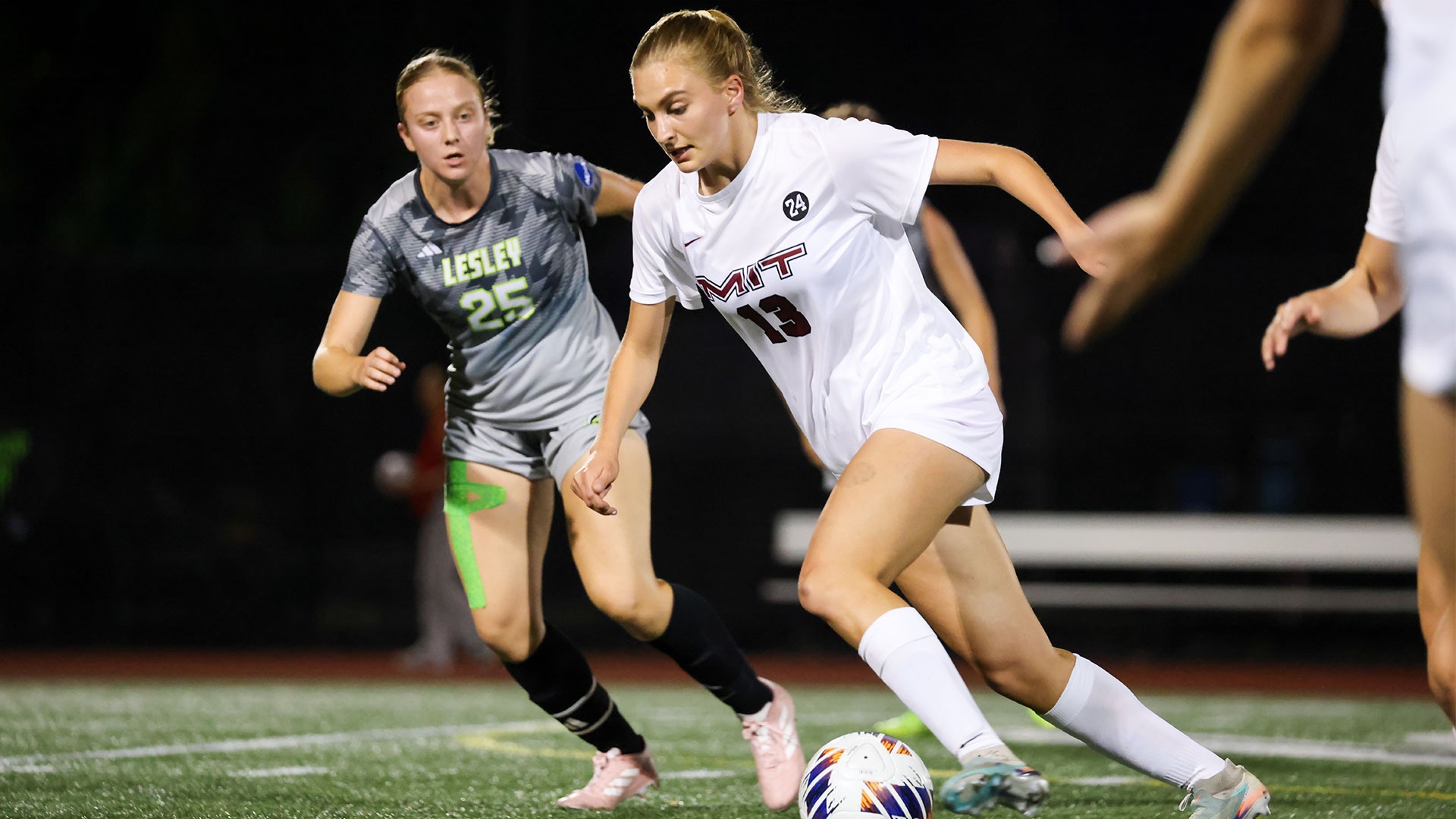 Ayla Sumer dribbling a soccer ball past defenders