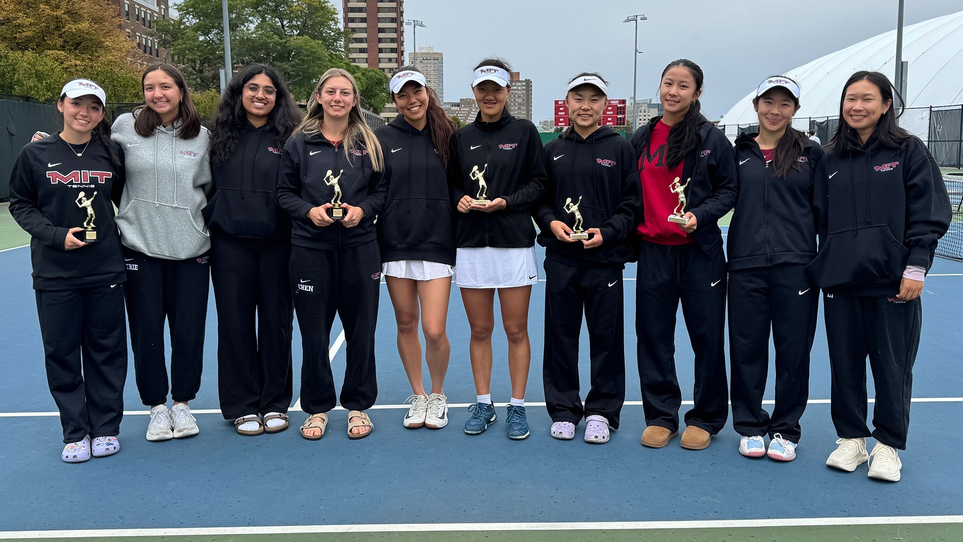 Members of the MIT women's tennis holding trophies