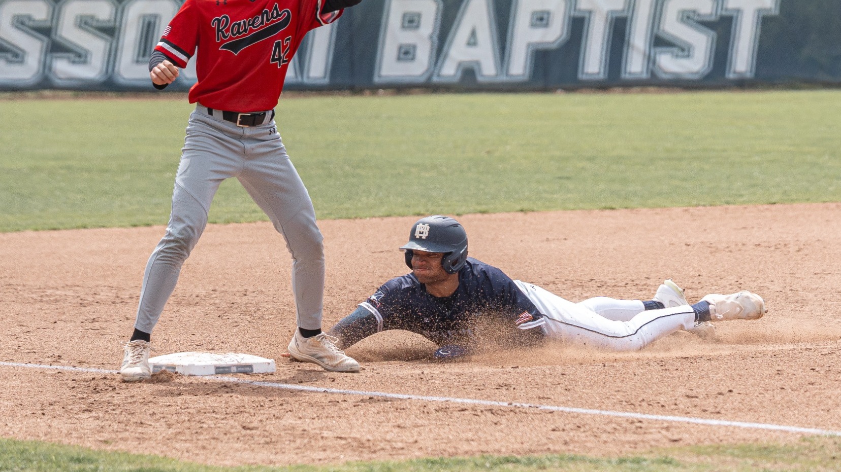 Carlos Hidalgo slides head first into third base versus Benedictine