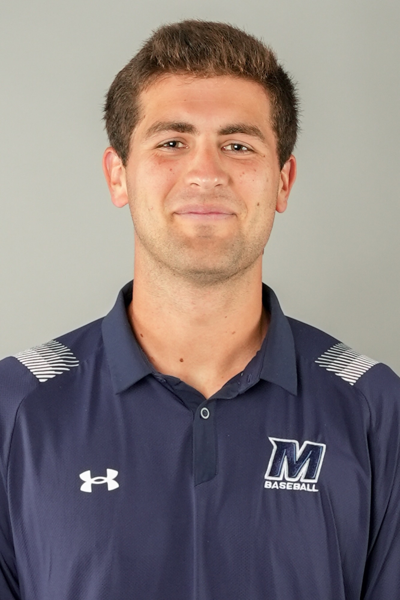 Travis Reifsnider (head and shoulders mug shot in a blue polo shirt with the M word mark 