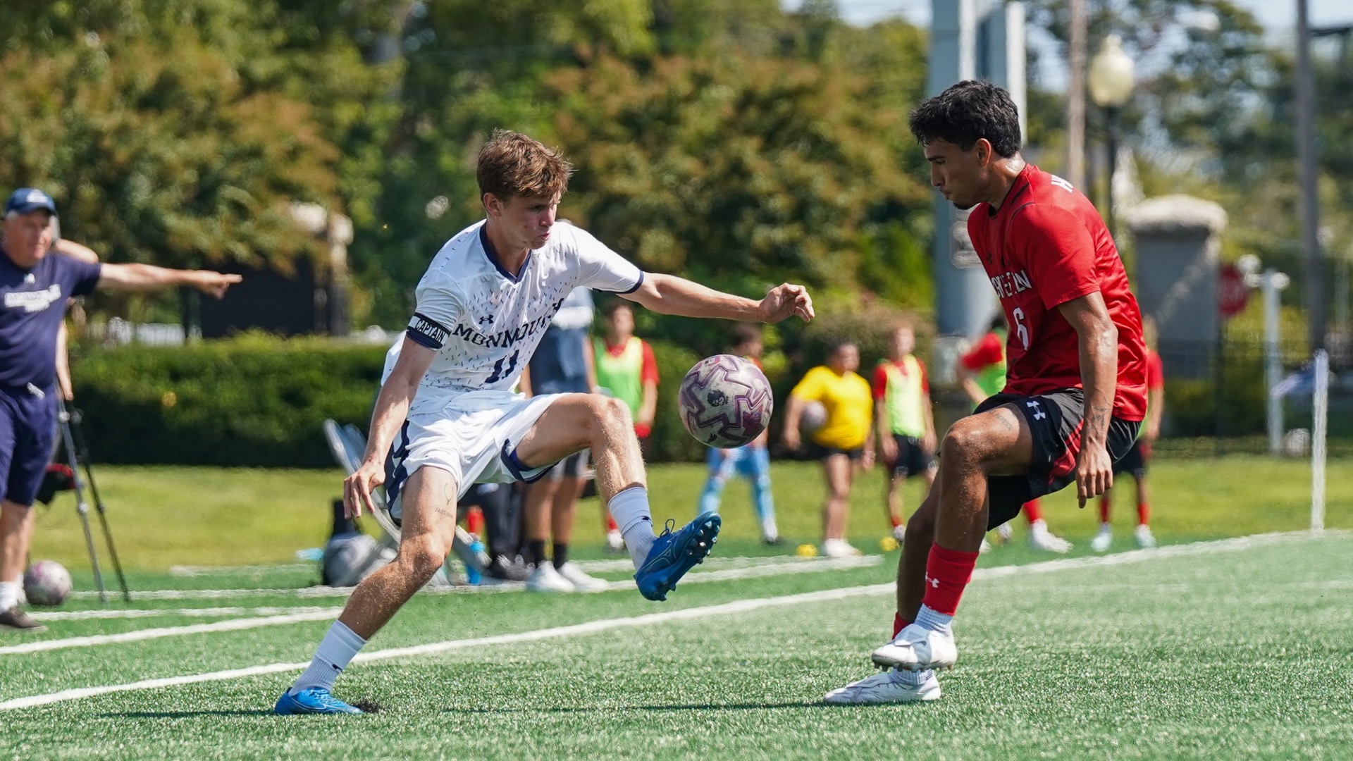 Jakob Friedman kicks a ball off a foot while a defender watches