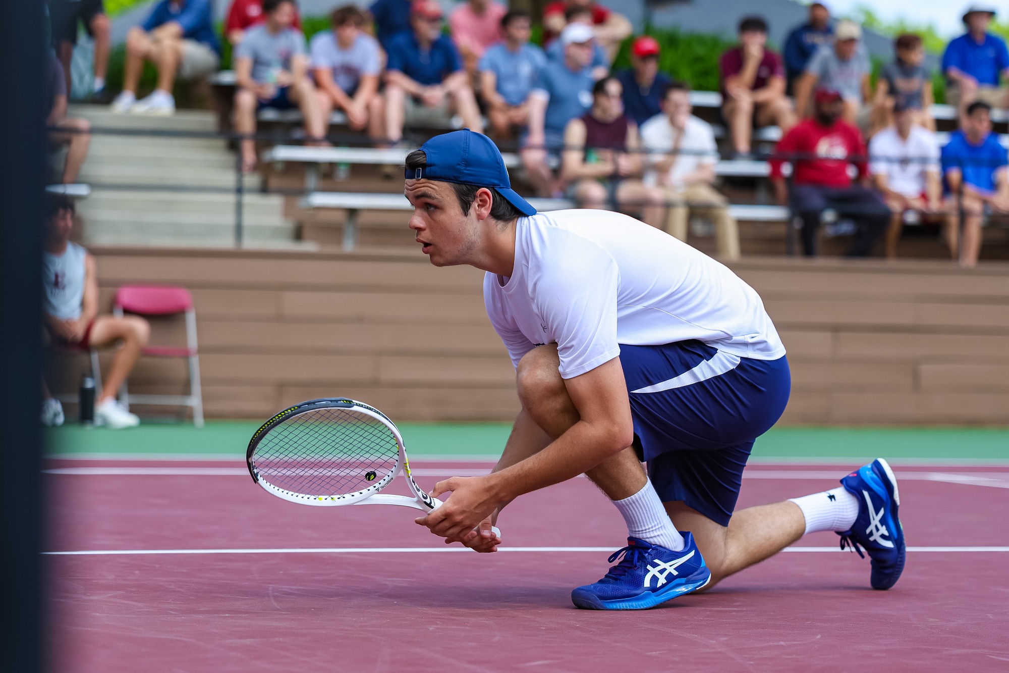 Louis Keller crouches over with his racquet in his hands