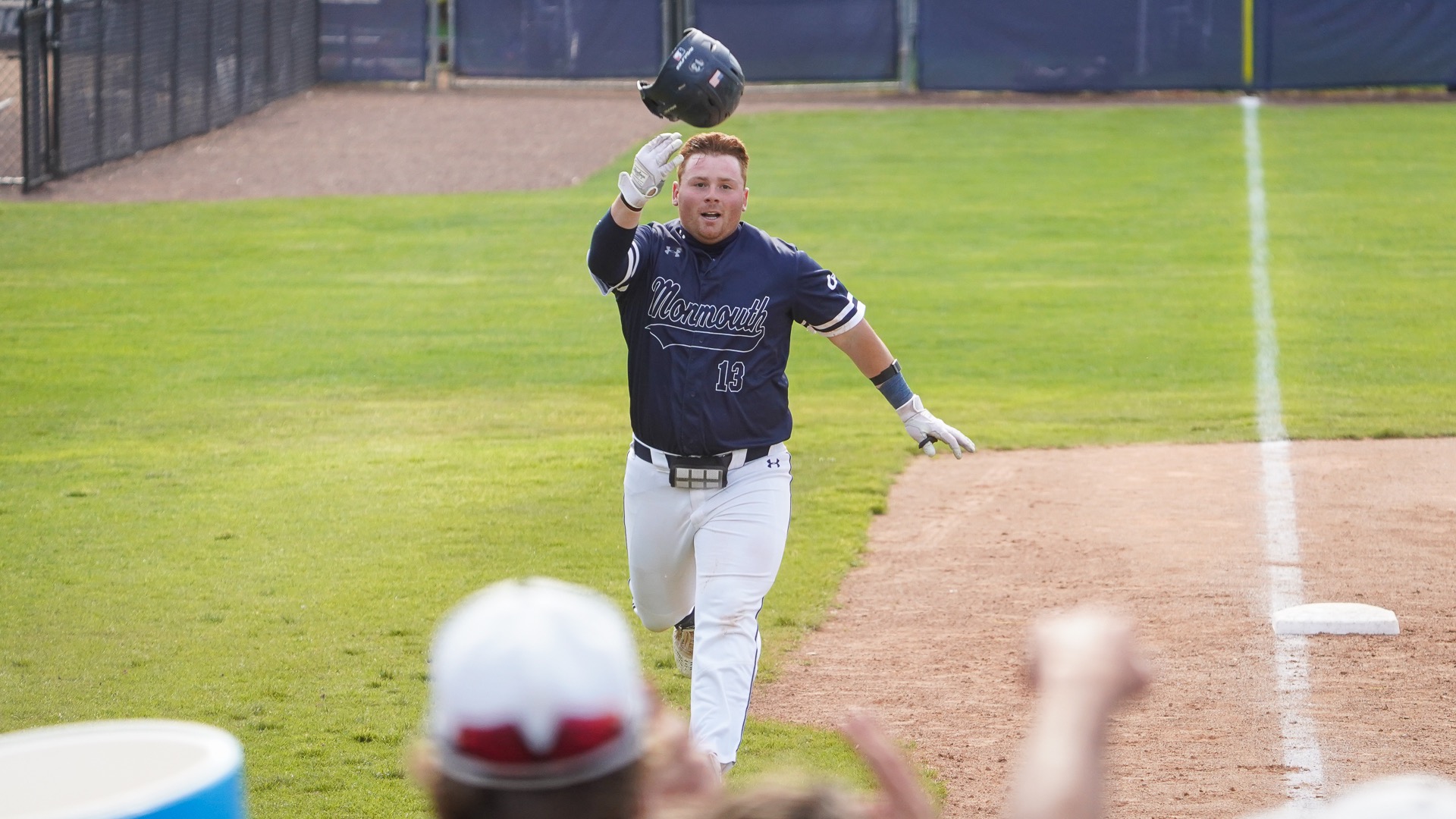 Jay Bant tosses his helmet as the Hawks gather at the plate to celebrate