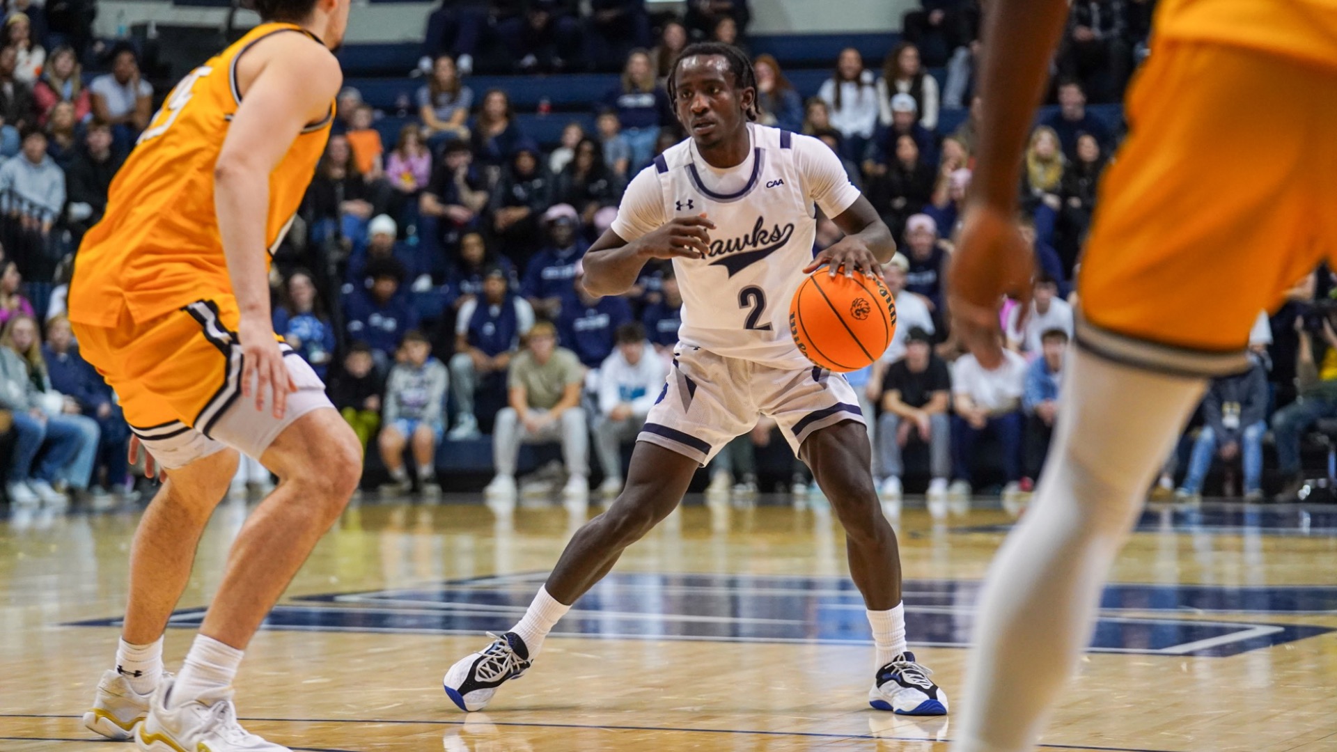 Kavion McClain dribbles the ball in between defenders