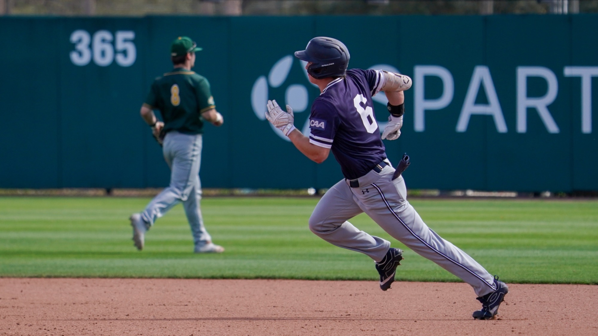 Colin Richter runs the bases while a fielder tries to get the ball