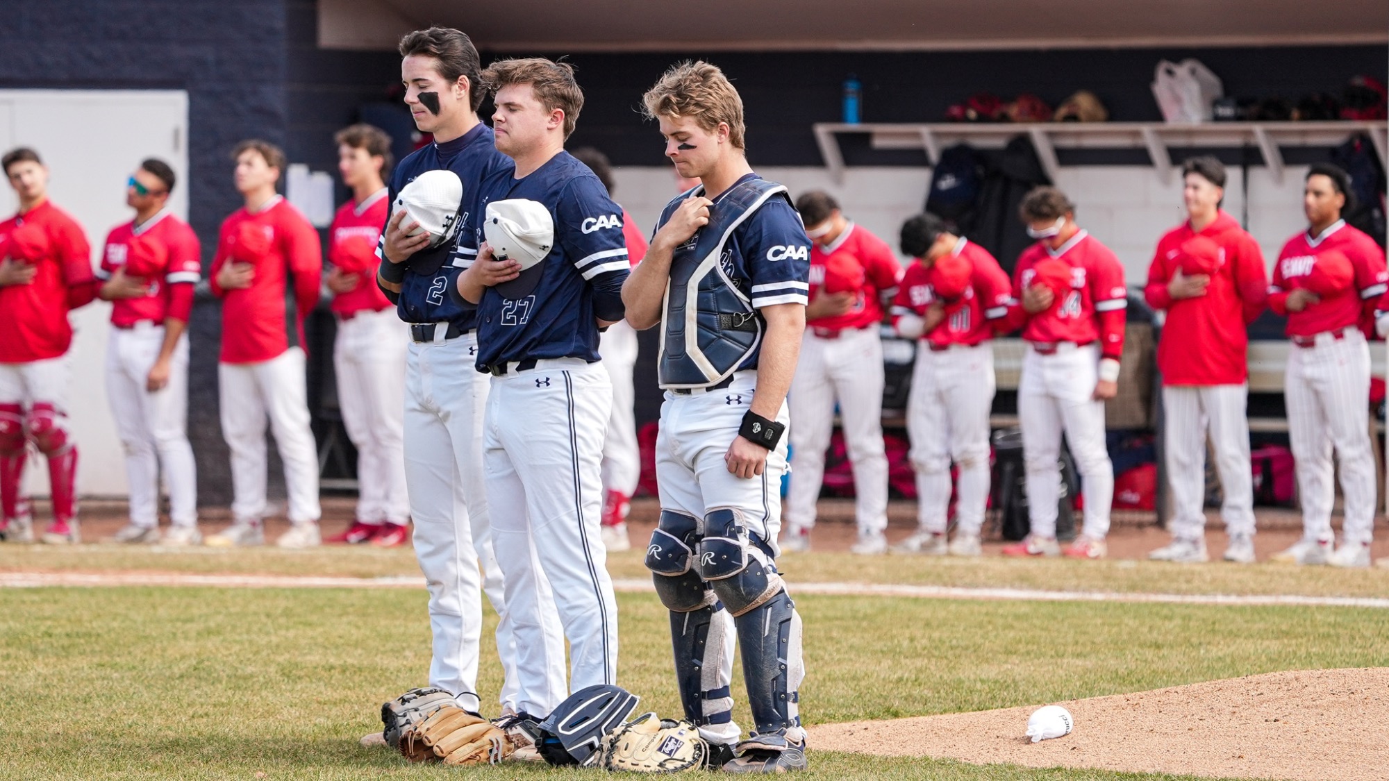 Chris Walsh, Brendan Kenneally and Brendan Buecker stand with their eyes closed for the national anthem
