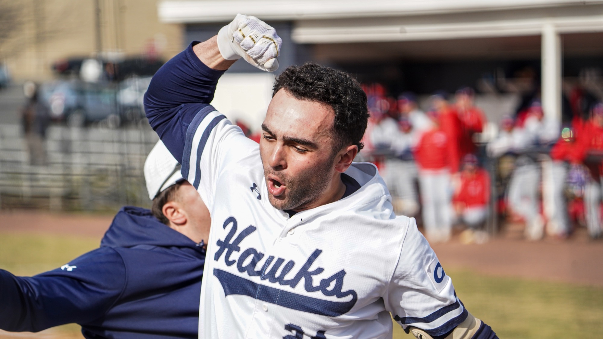 Nick Lovarco raises an arm and yells as he celebrates a home run