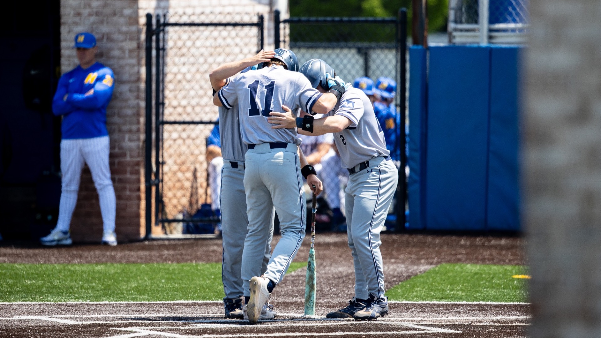 Aidan Bretschneider, Nick Lovarco and Brendan Büecker celebrate with their heads together at the plate