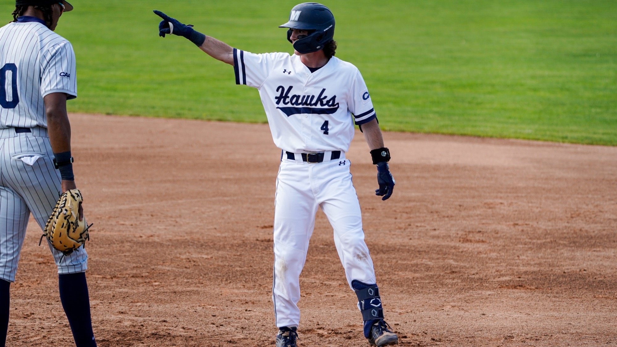 Jimmy Bruno points towards the dugout while standing on first base