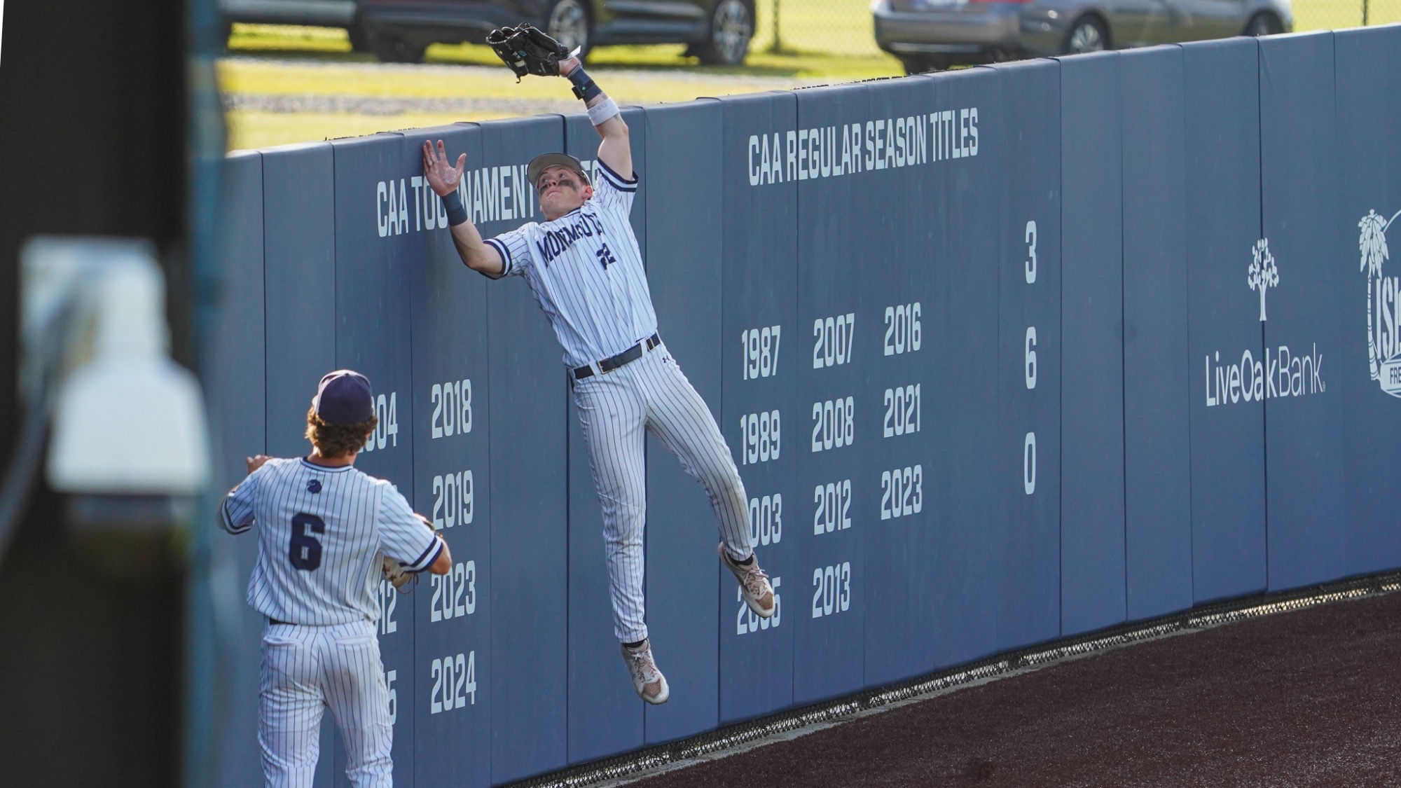 RJ Mustaro jumps up into the wall to make a catch as Colin Richter watches