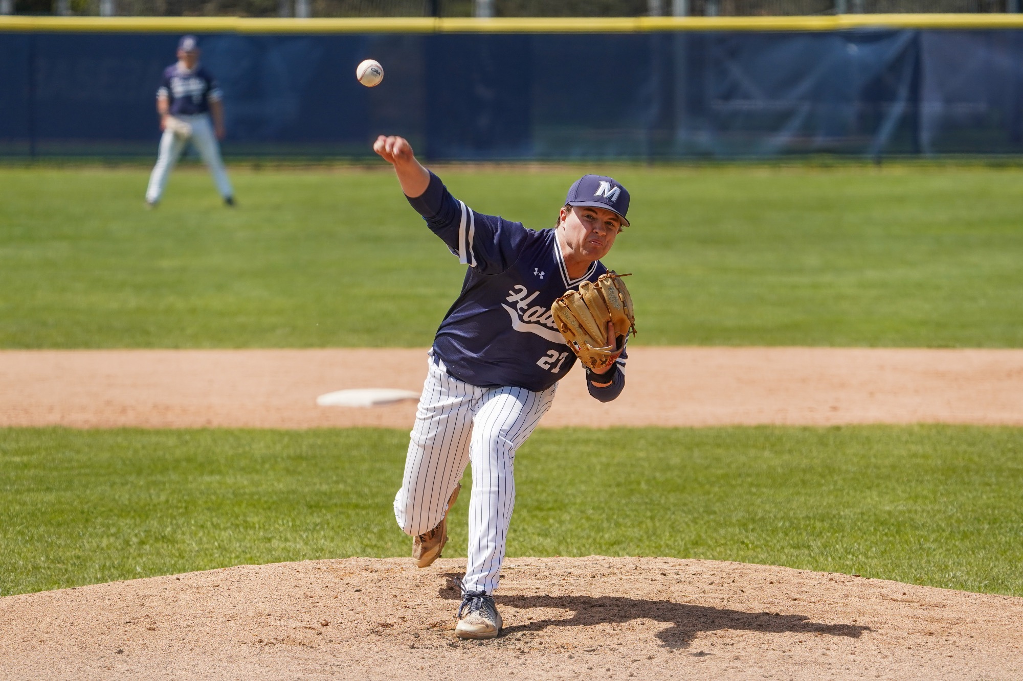 Brendan Kenneally lifts a hand over his head to throw a pitch