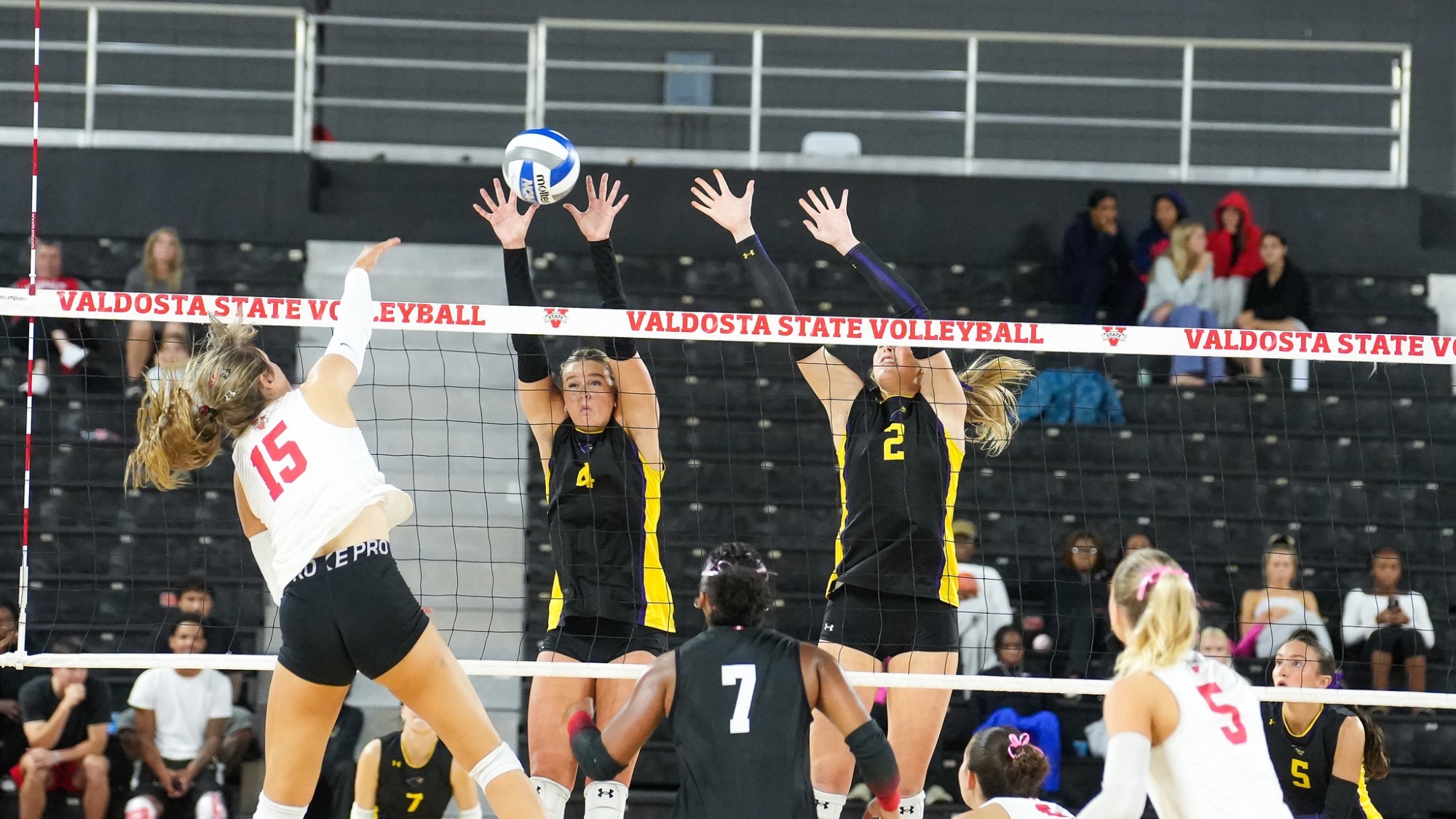 Two Montevallo volleyball players rise for a block against a Valdosta State attacker during Friday night’s match in Valdosta, Georgia.