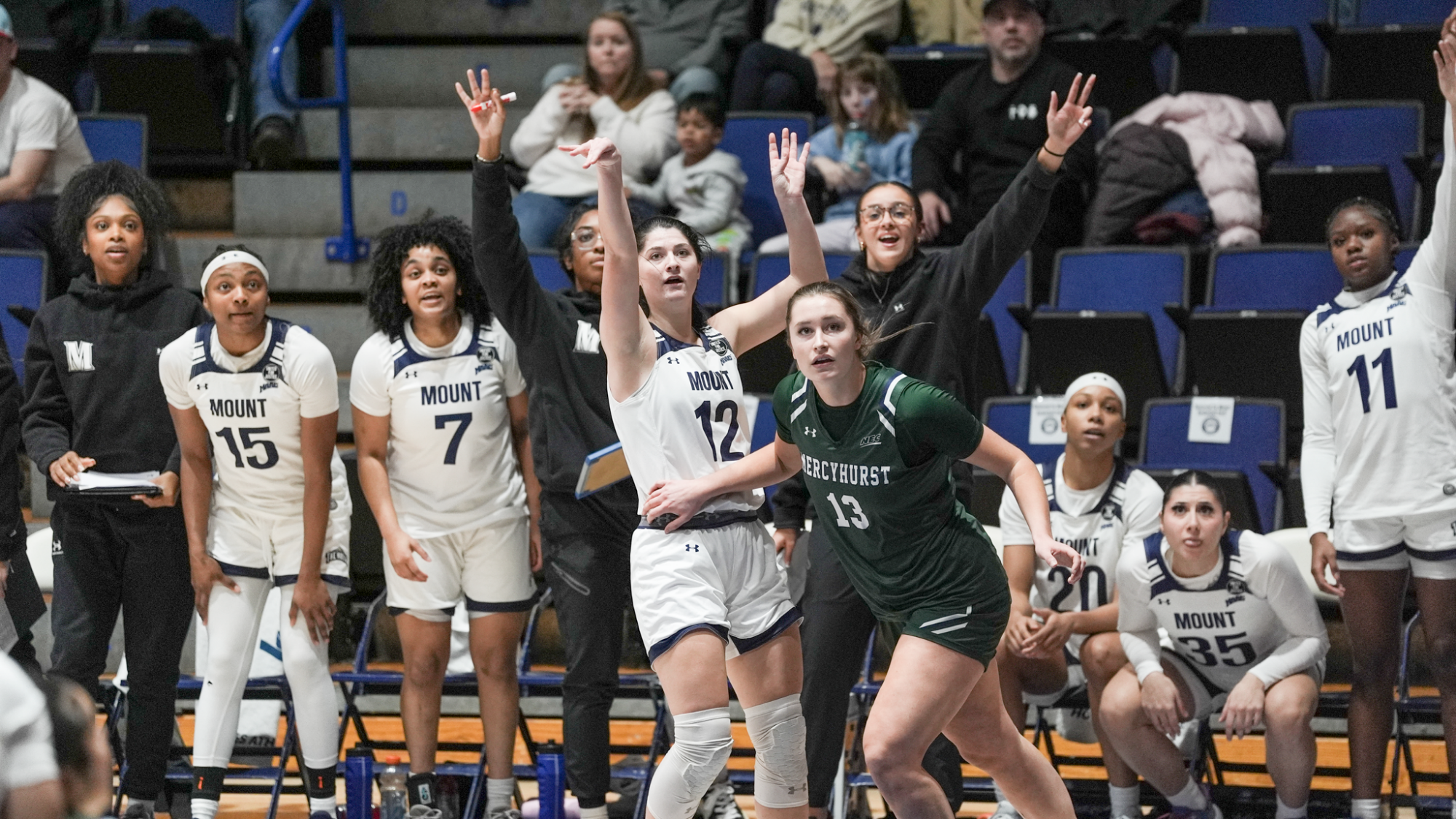Giana Hoddinott and the Bench Behind Her Watches a Three-Point Attempt 