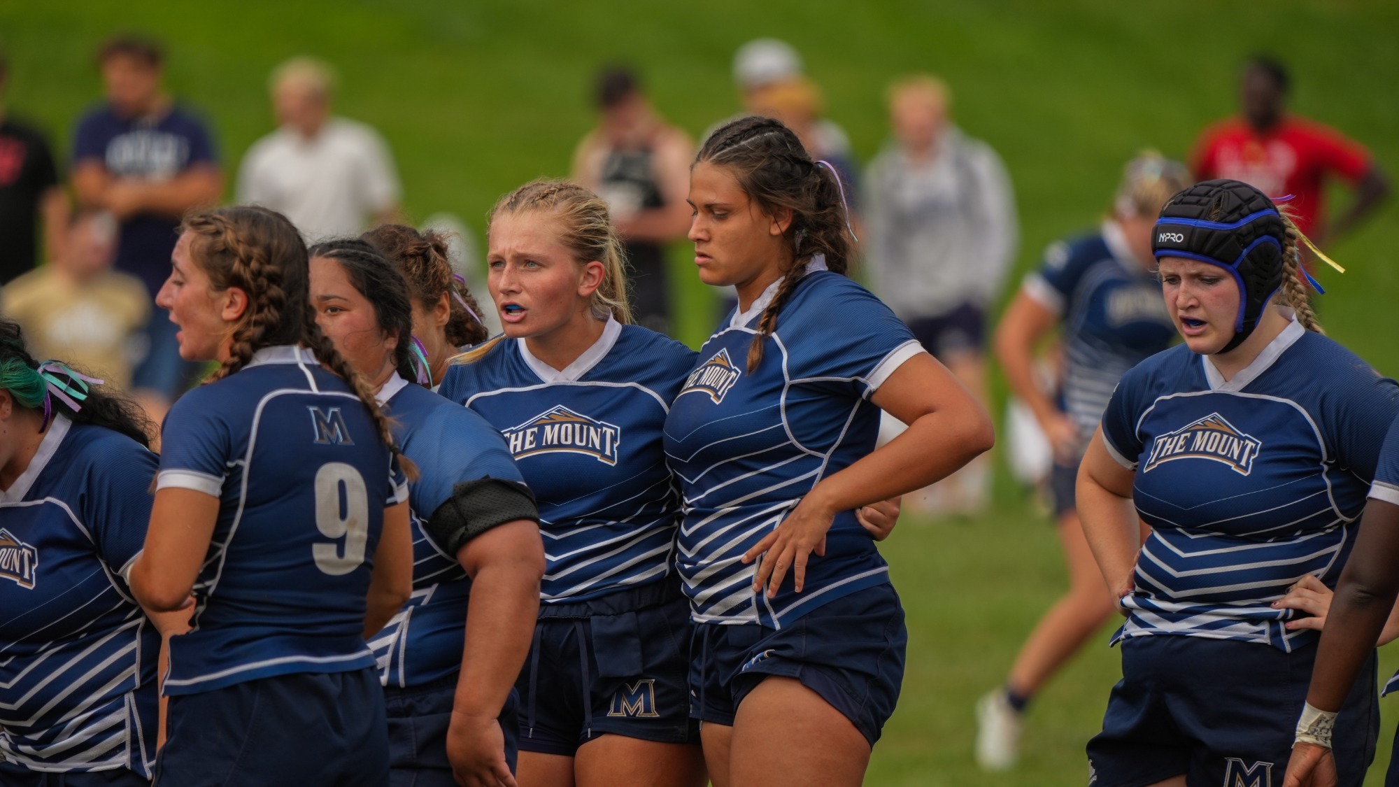 Women's Rugby Players Standing in Huddle 