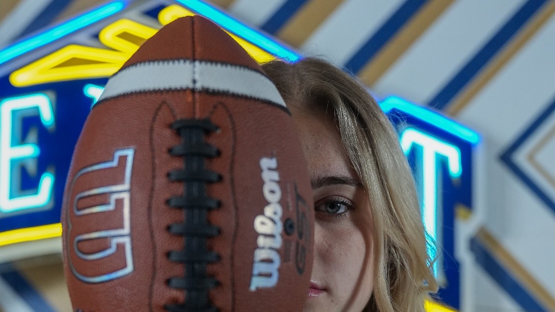 Jenna Dick Holds Up a Football at Media Day