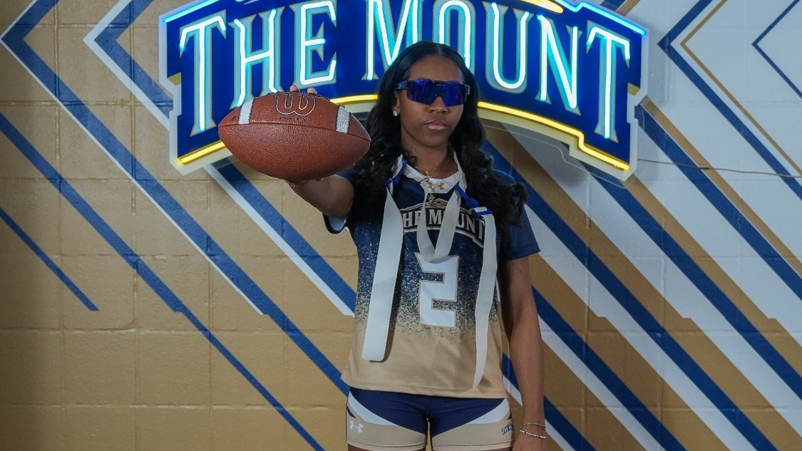 Alyssa Lane Sporting Sunglasses and Holding Out a Football