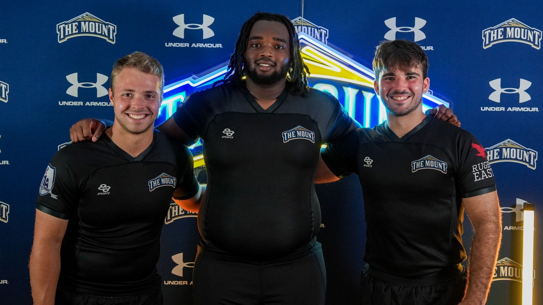 Three Players from Men's Rugby Pose for a Media Day Photo