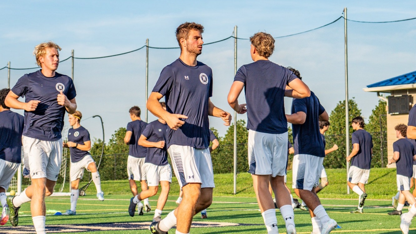 Members of the Men's Soccer Team Running in Warmups