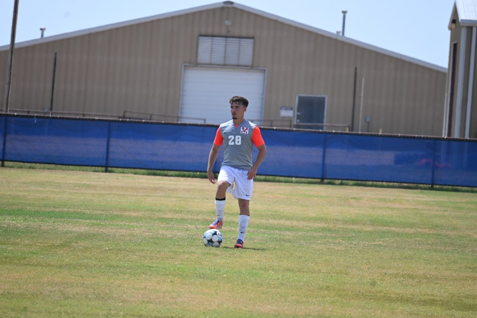 #28 men's soccer with foot on ball