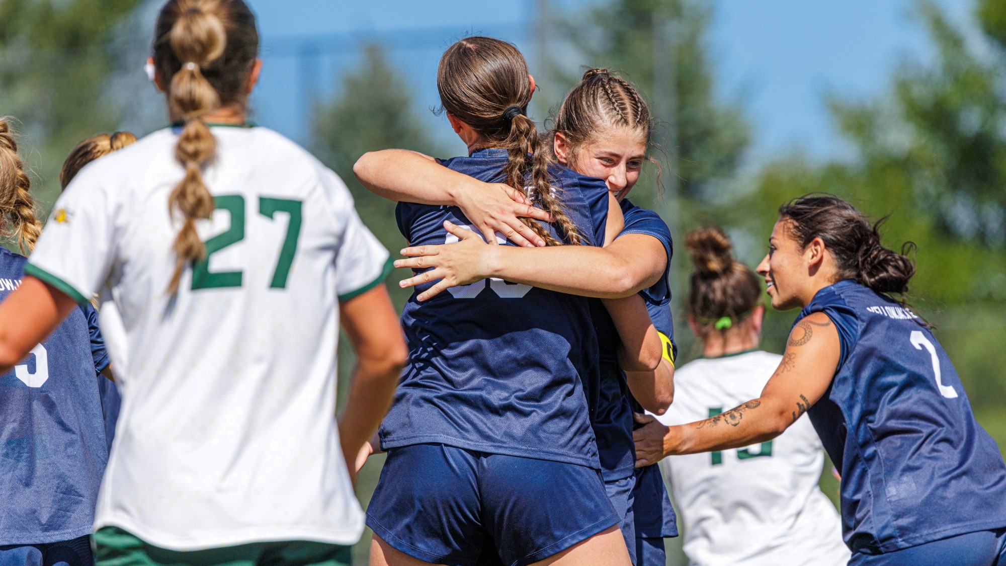 Ava Gibbs and Kelsie Cox hug and celebrate scoring and assisting MSUB's first goal against Black Hills State