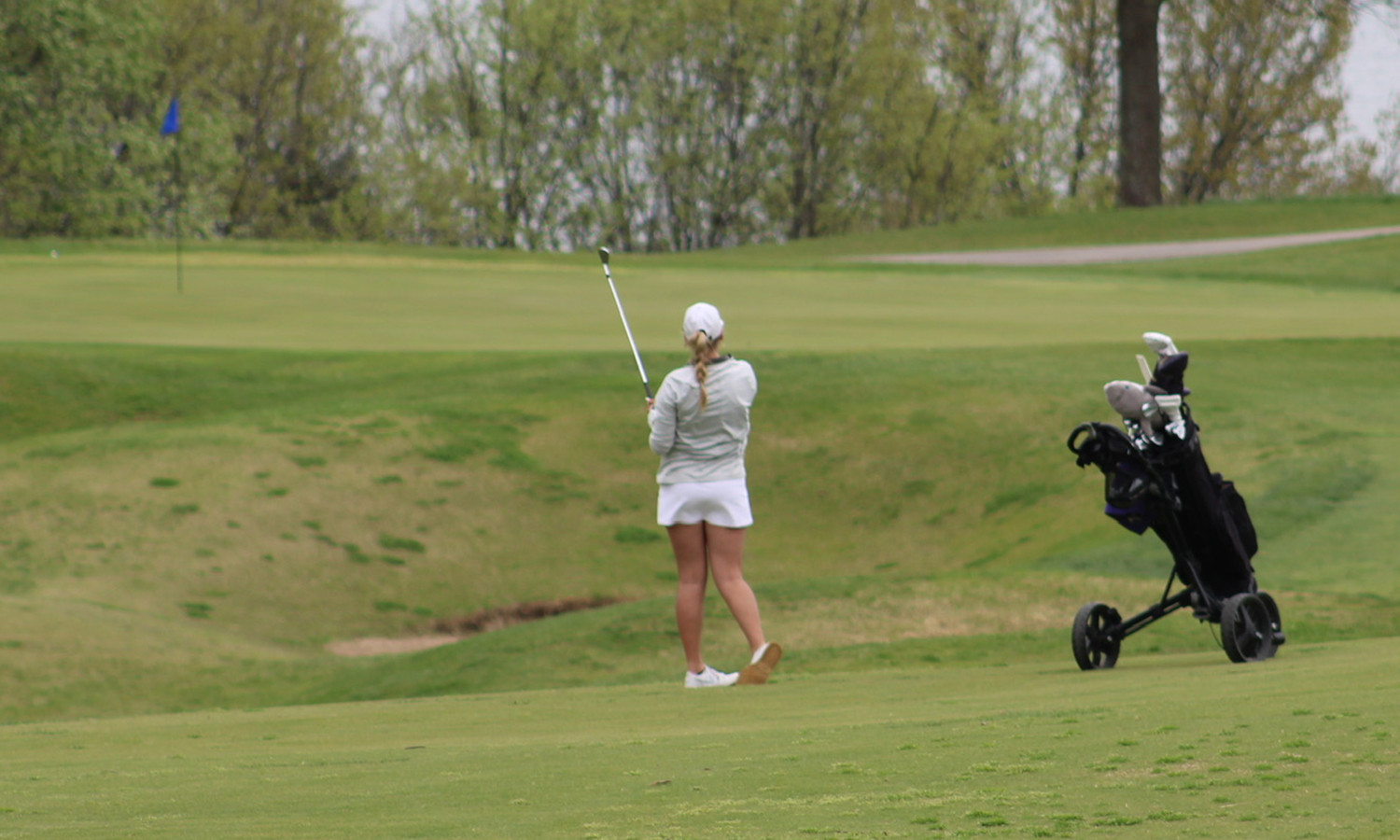 Emerson Garlie hits an approach shot at the NSIC Championships