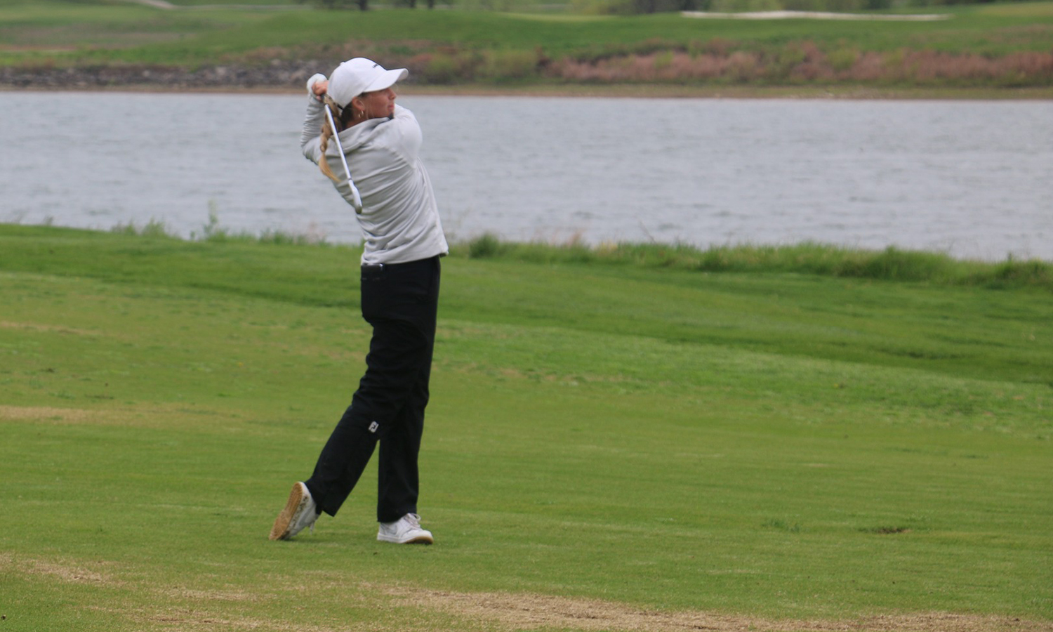 Emerson Garlie hits an approach shot at the NSIC Championships