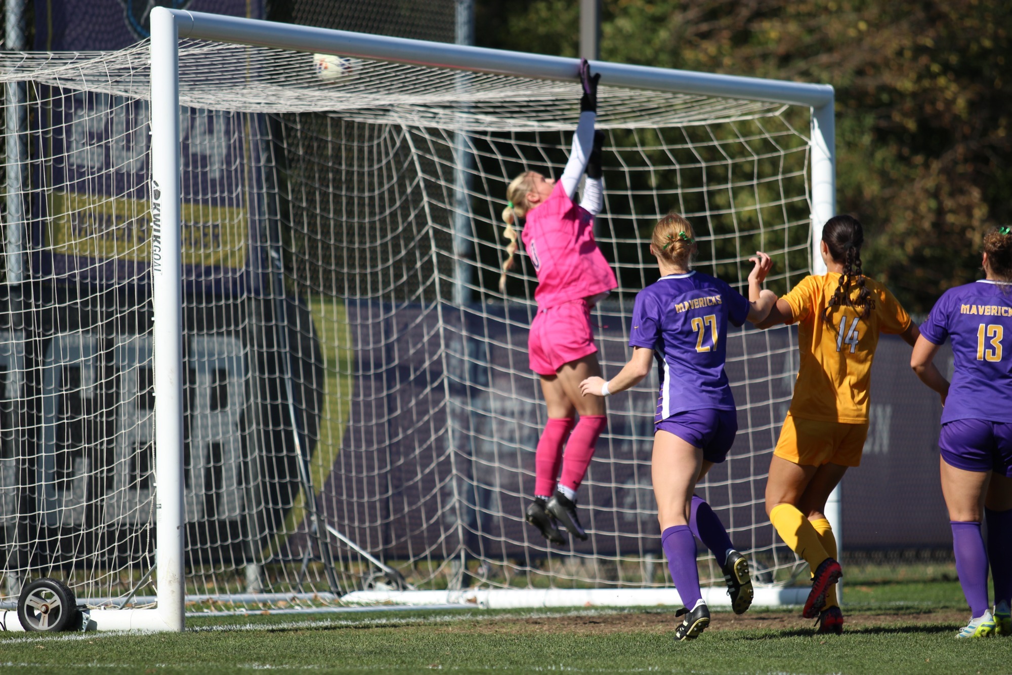 Lauren McAlpine punches the ball over the net for a save