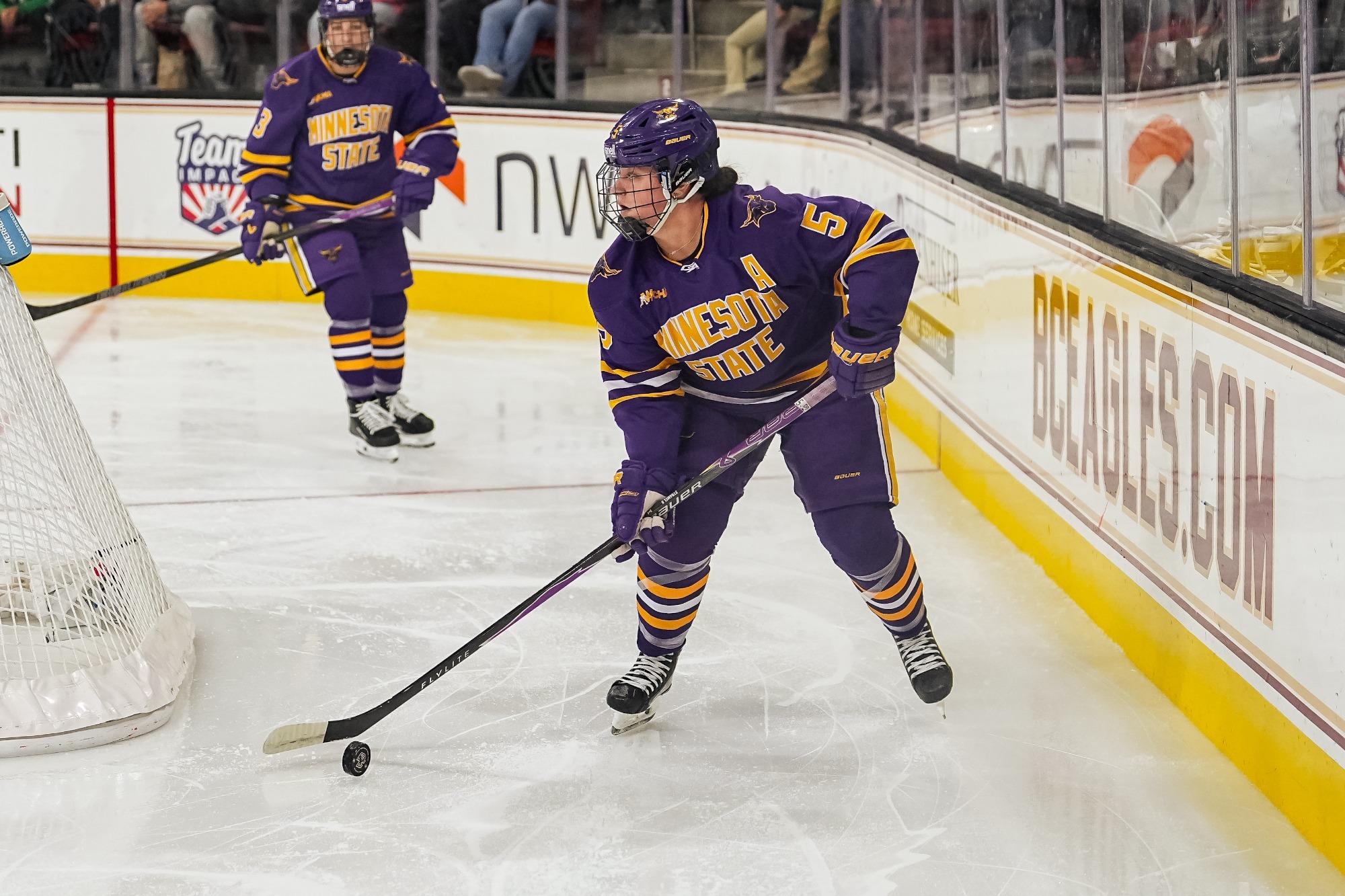 Sophie Stramel skates with the puck behind the net