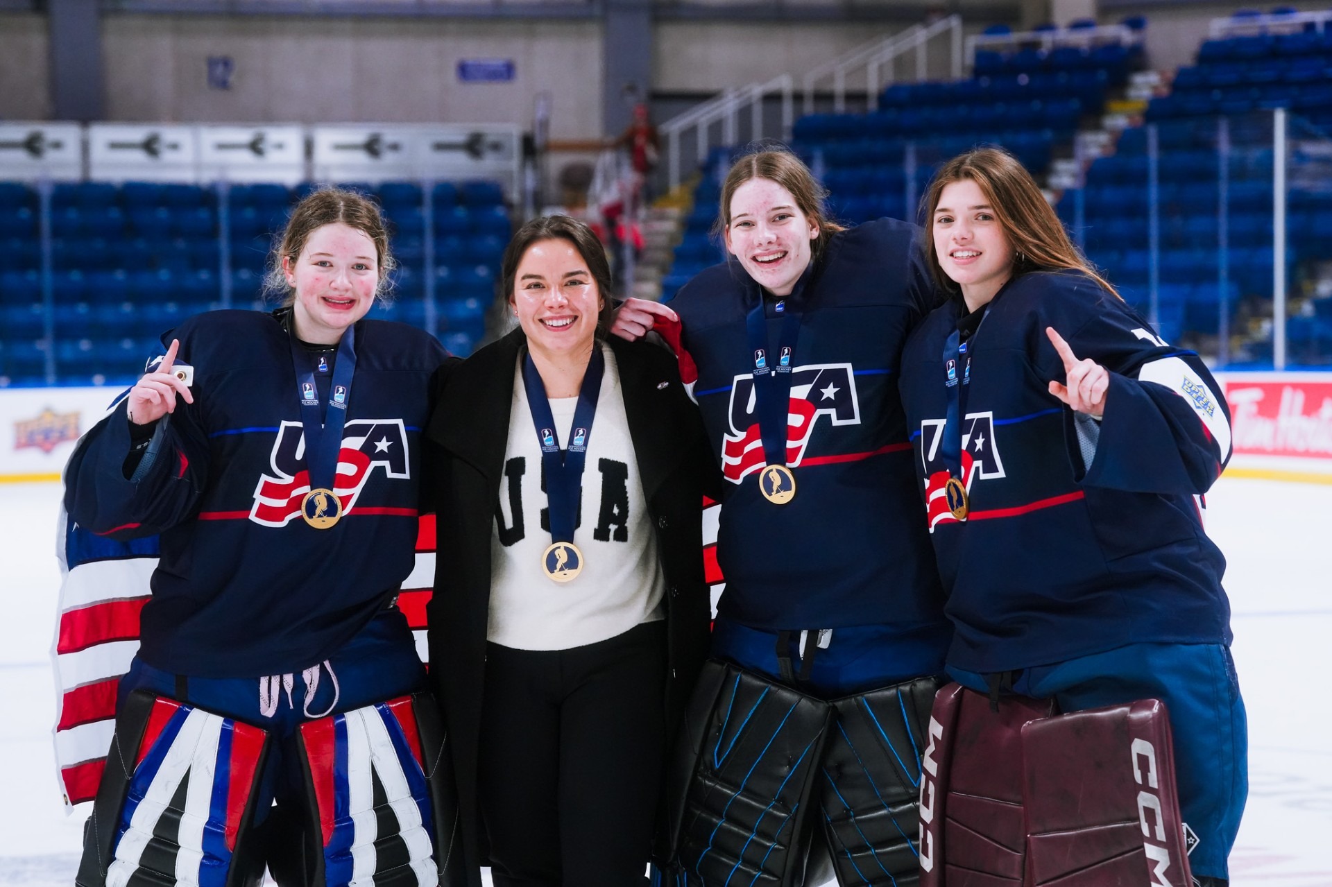Minnesota State assistant coach Mackenzie Bruch poses with members of Team USA following their gold medal at the 2026 U18 Championships