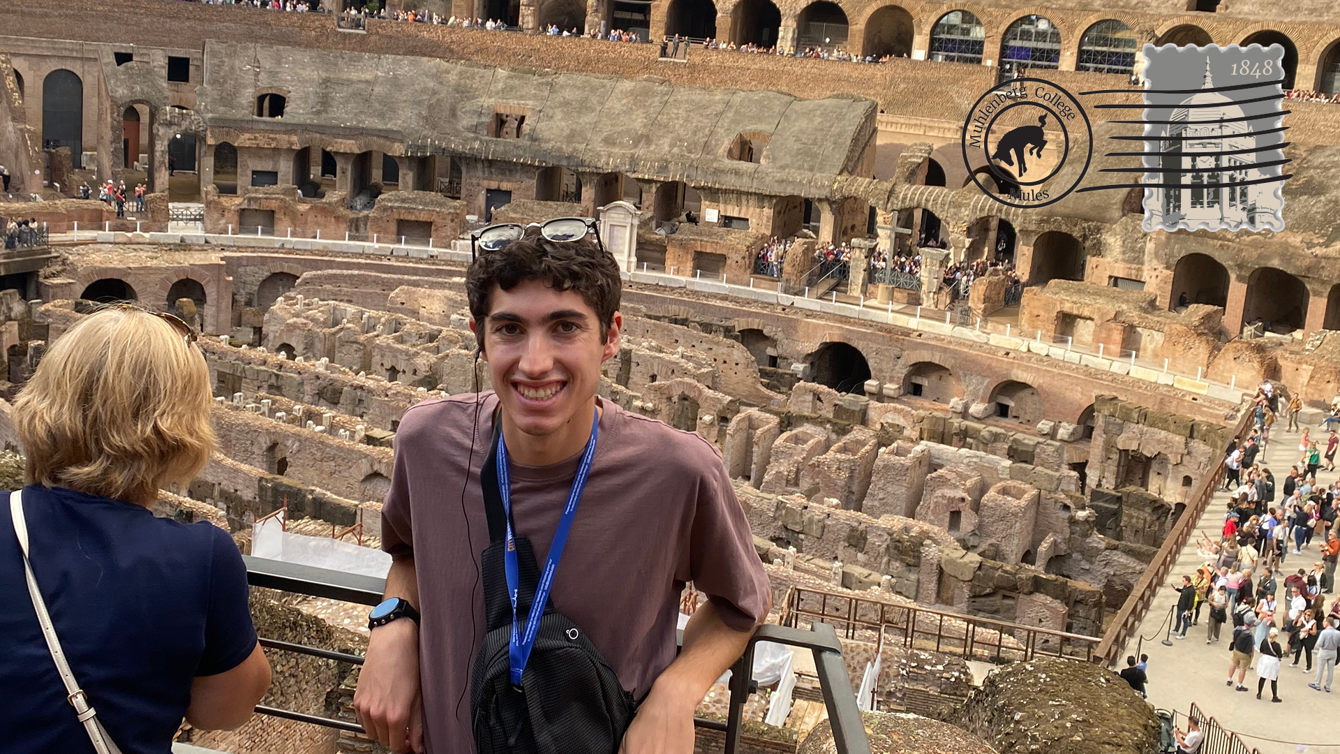 A young man poses in front of ruins in Rome
