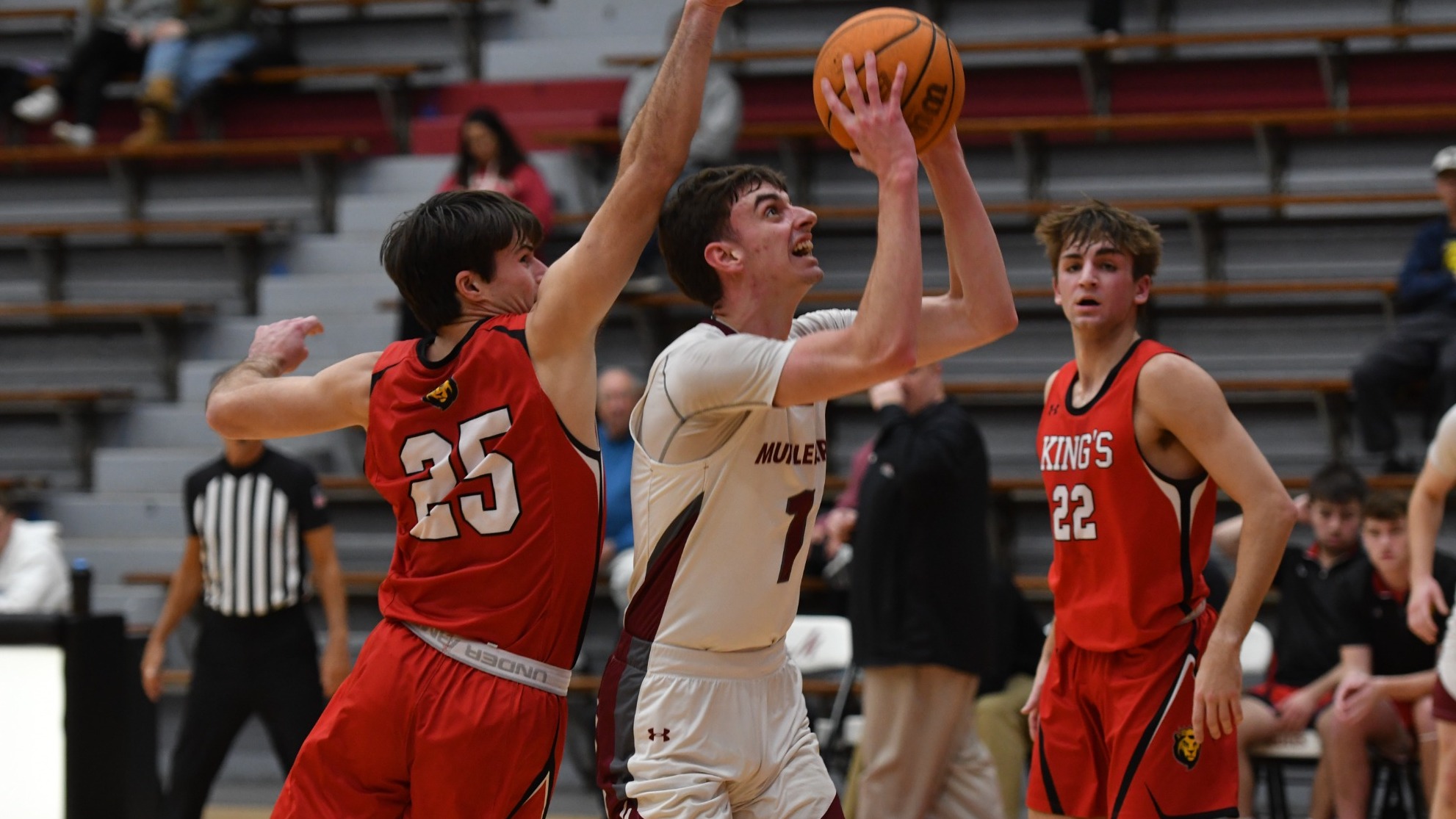A basketball player in a white uniform attempts a shot at the rim while defended by a player in a red uniform