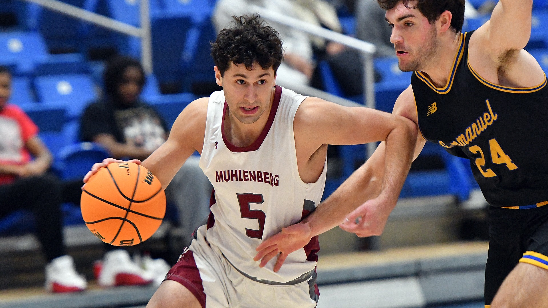a basketball player in a white uniform driving on a player in a black uniform