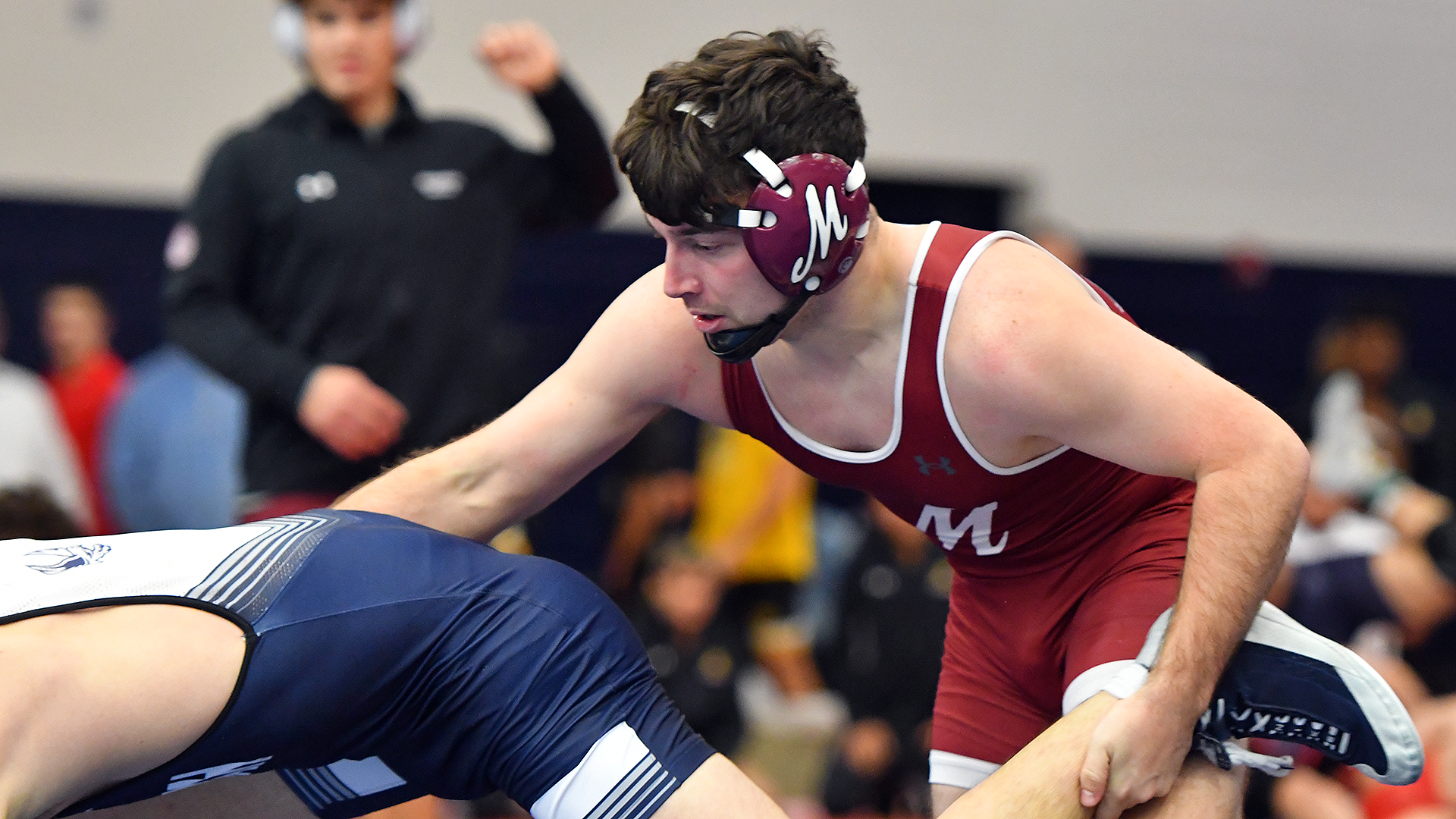 A wrestler in a red singlet takes down one in a blue singlet 