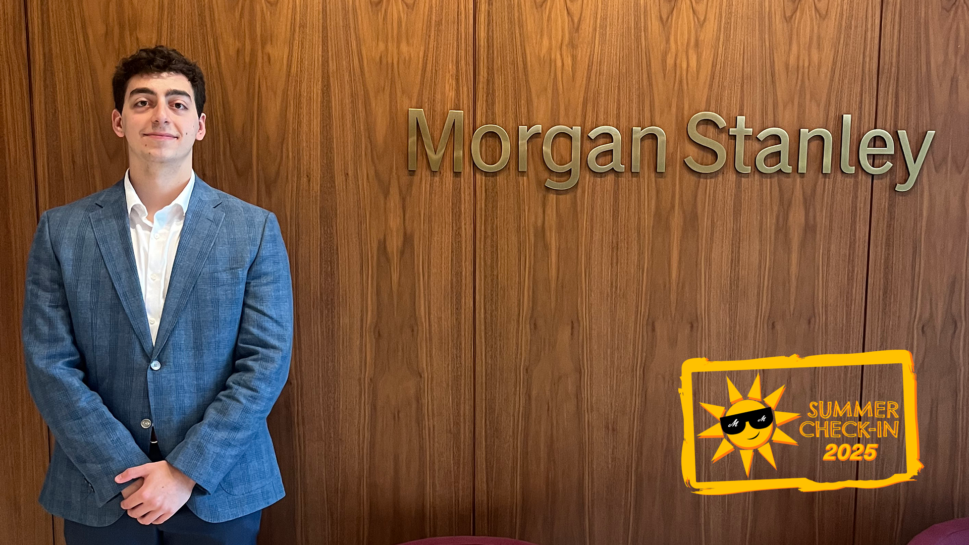 A young man in a light blue jacket stands in front of a brown wall with the words Morgan Stanley in gold