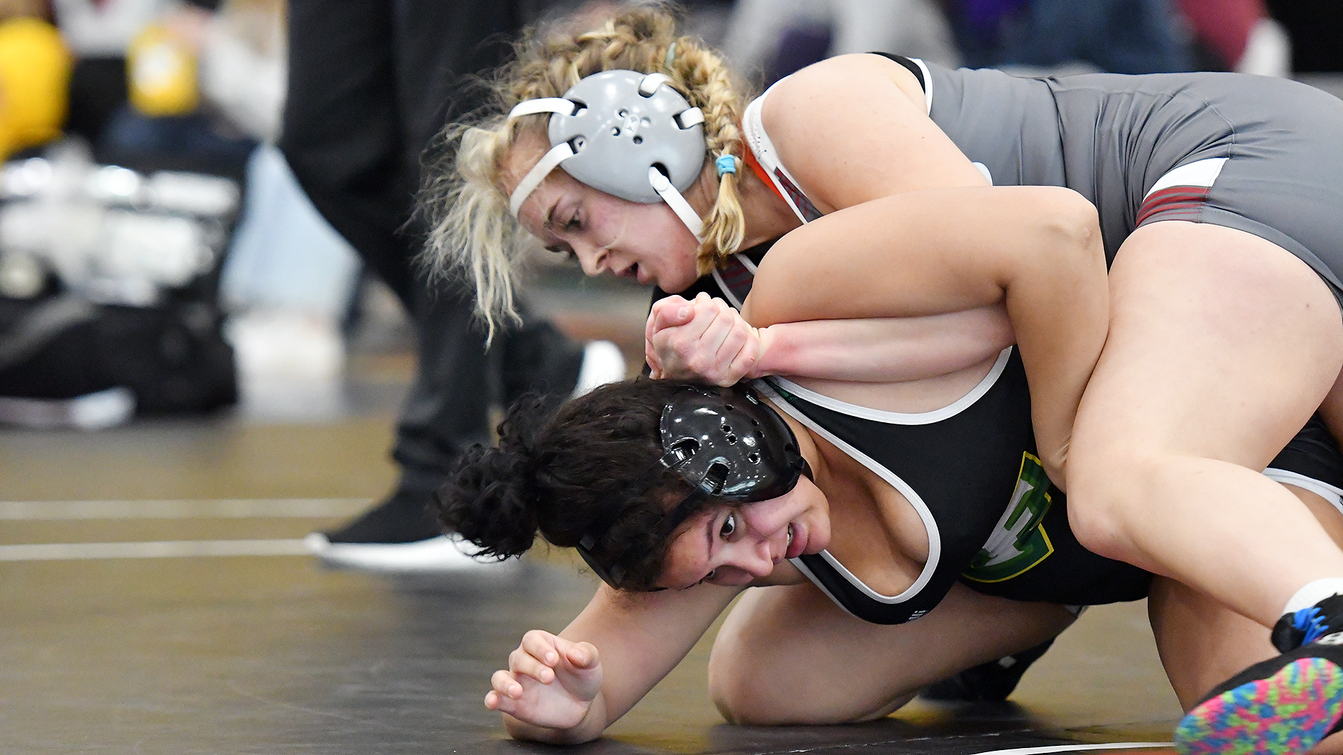 a wrestler in a grey singlet on top of one in a black singlet