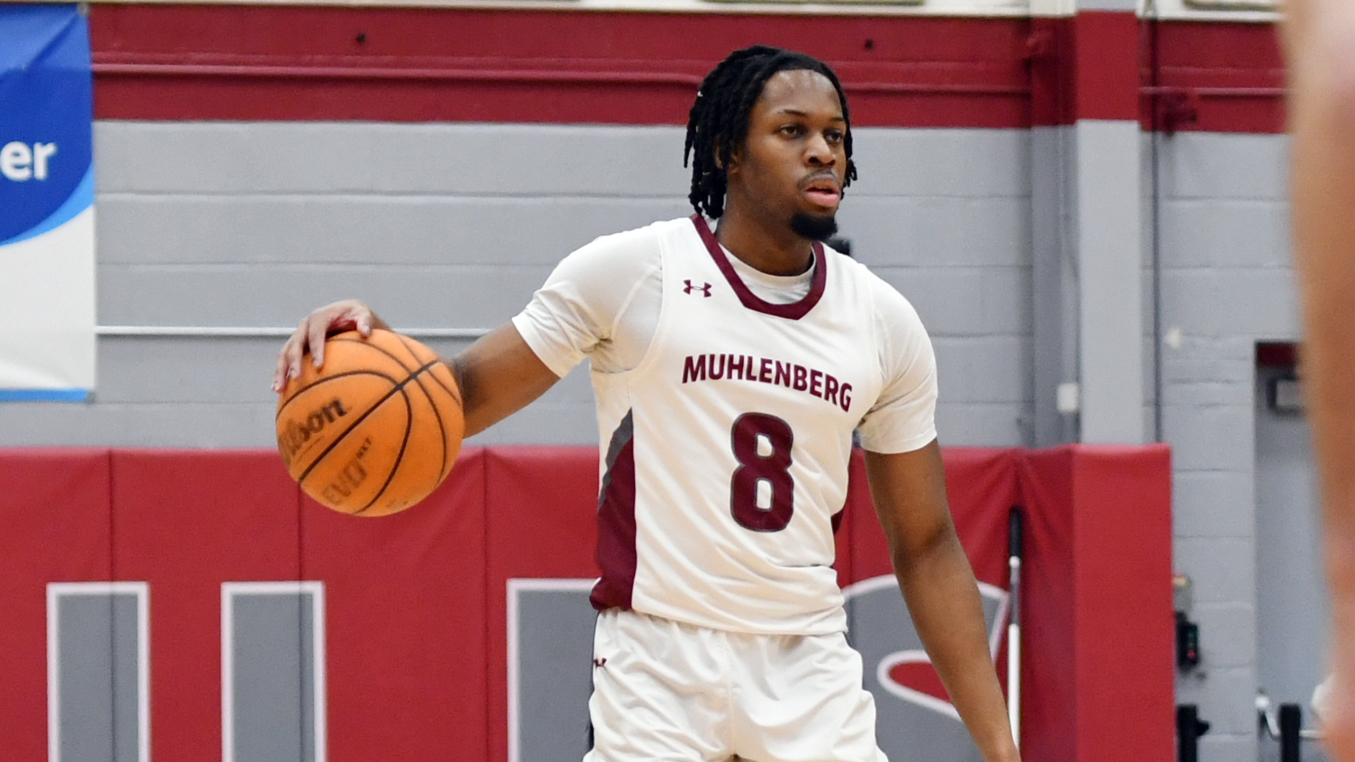 a basketball player in a white uniform dribbles the ball