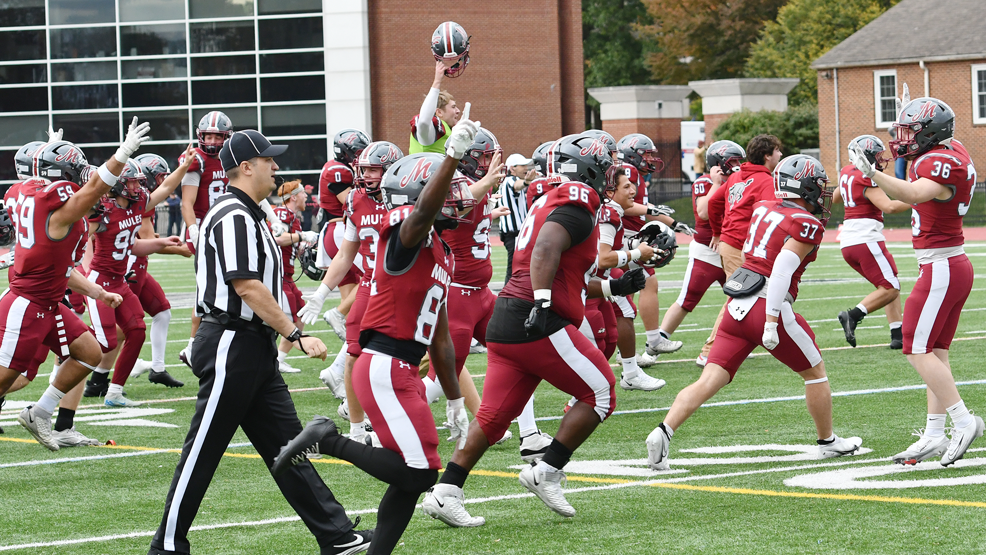 football players in red jerseys rush onto the field to celebrate a win