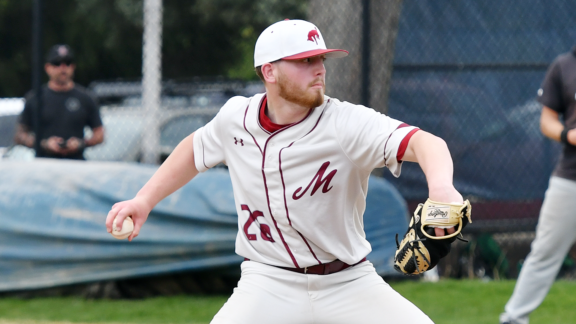side view of a righthanded pitcher in a white uniform delivering a pitch