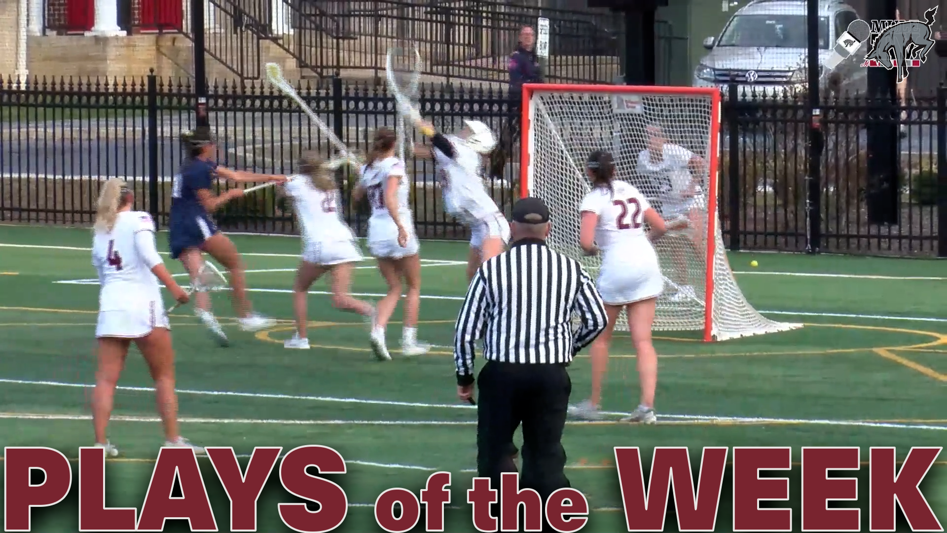 a women's lacrosse goalie in a white uniform raising her stick to save a shot taken by a player in a navy blue uniform, with the text Plays of the Week in red at the bottom
