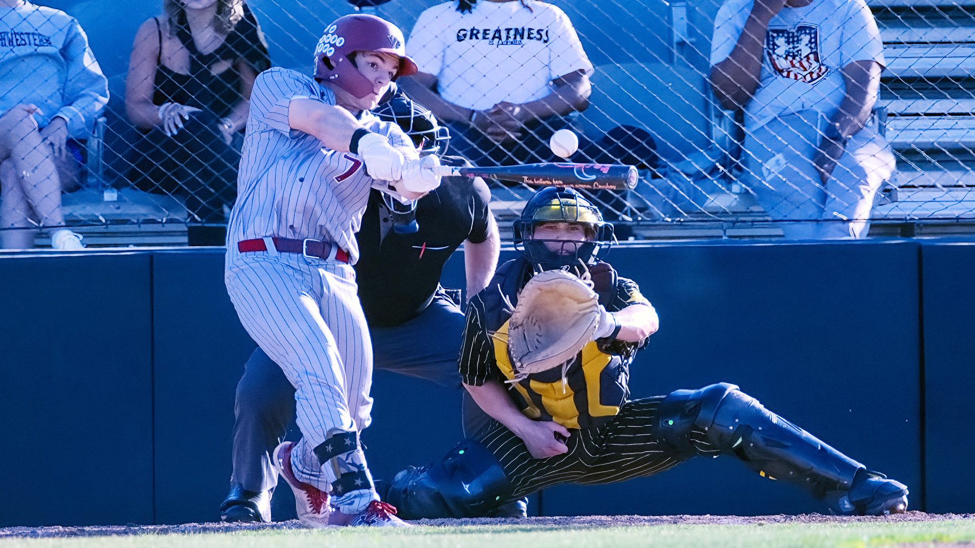 a baseball player in a grey pinstriped uniform making contact with the baseball as viewed from center field