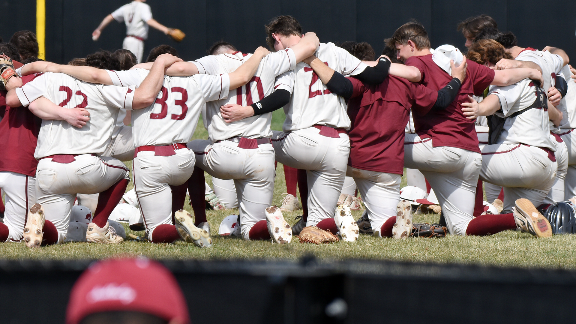 baseball players in white uniforms kneeling together
