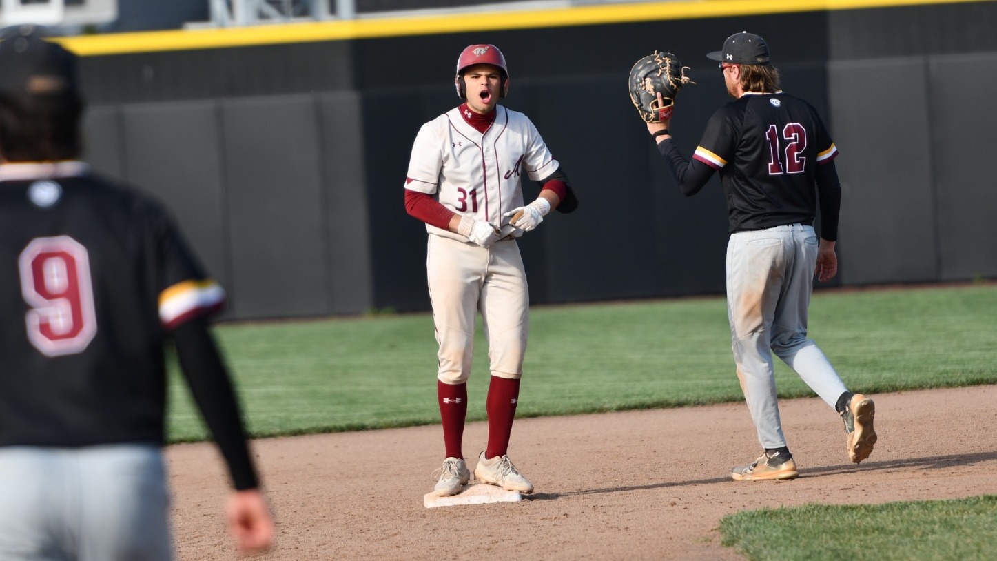 A baseball player wearing #31 stands on base reacting after a play while an opposing fielder looks on nearby.