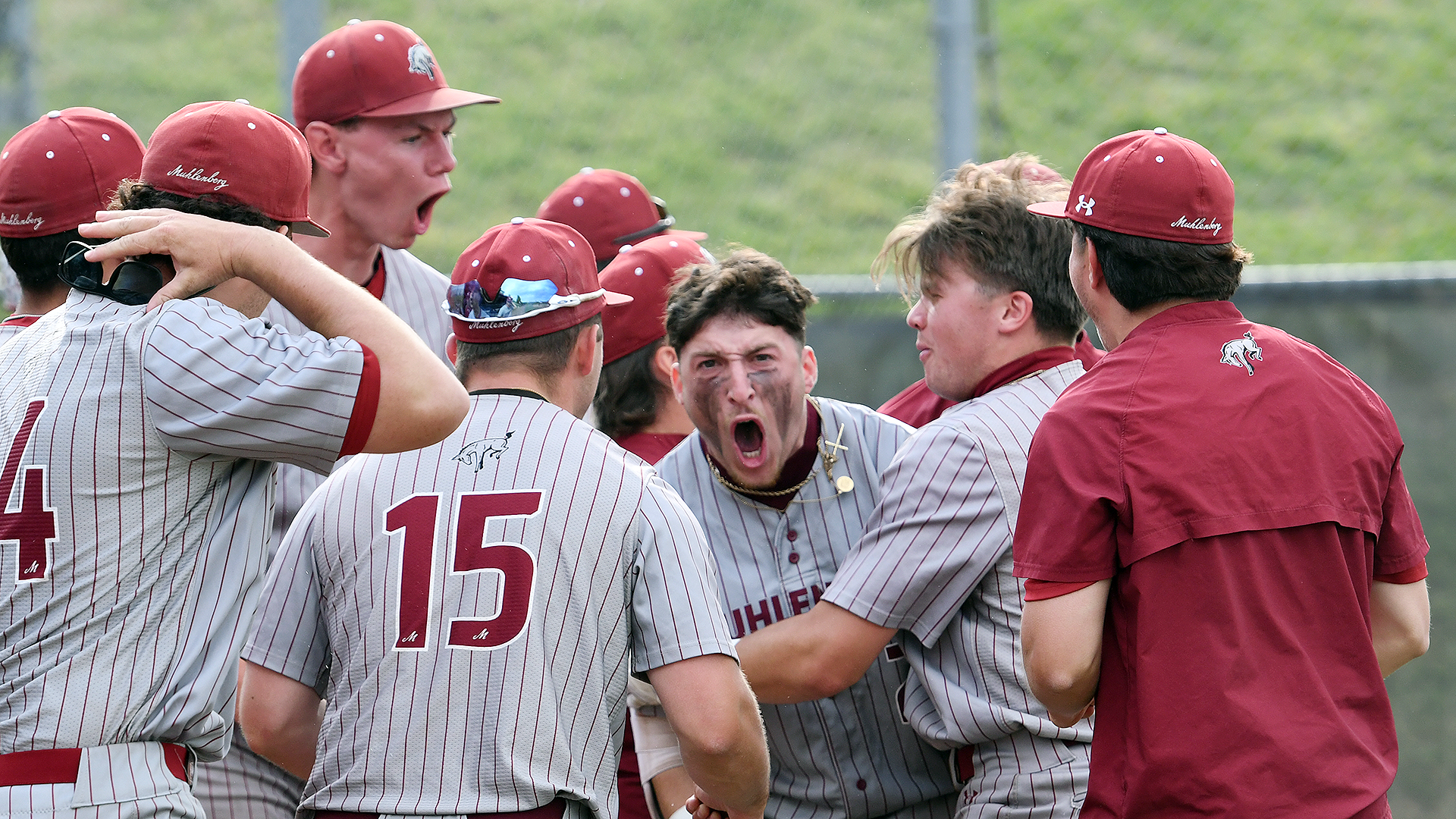 baseball players in grey jerseys with red pinstripes celebrating a home run
